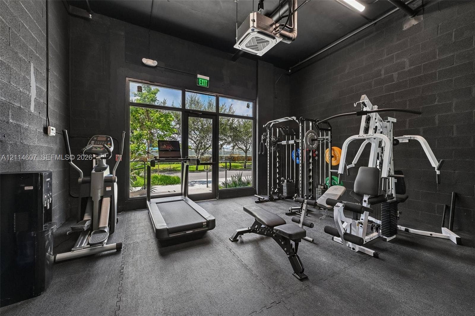 2479 NE 192nd Street, #103, Miami, Miami, FL 33180 Exposed masonry walls finished in matte black, high ceilings, industrial-style exposed ductwork, rubberized flooring, and floor-to-ceiling glass entry doors