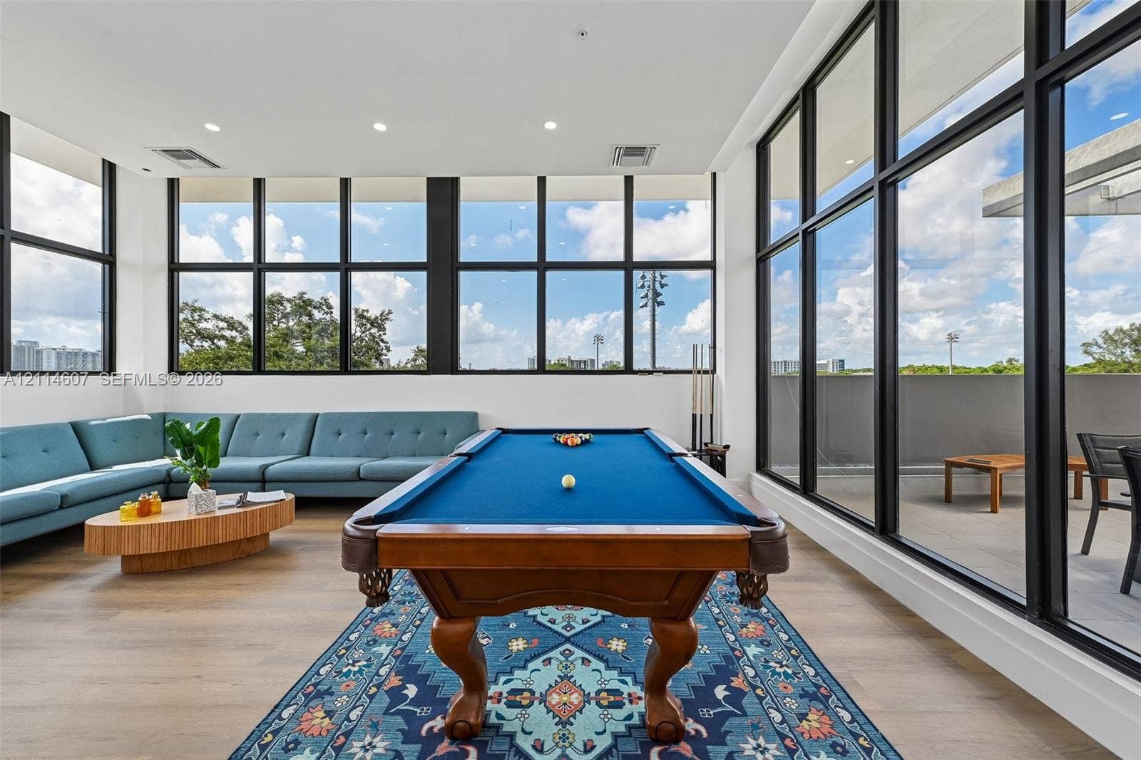 2479 NE 192nd Street, #103, Miami, Miami, FL 33180 Fitness area featuring painted concrete block walls, durable rubberized flooring, an exposed ceiling structure, and floor-to-ceiling glass paneling with an exterior door