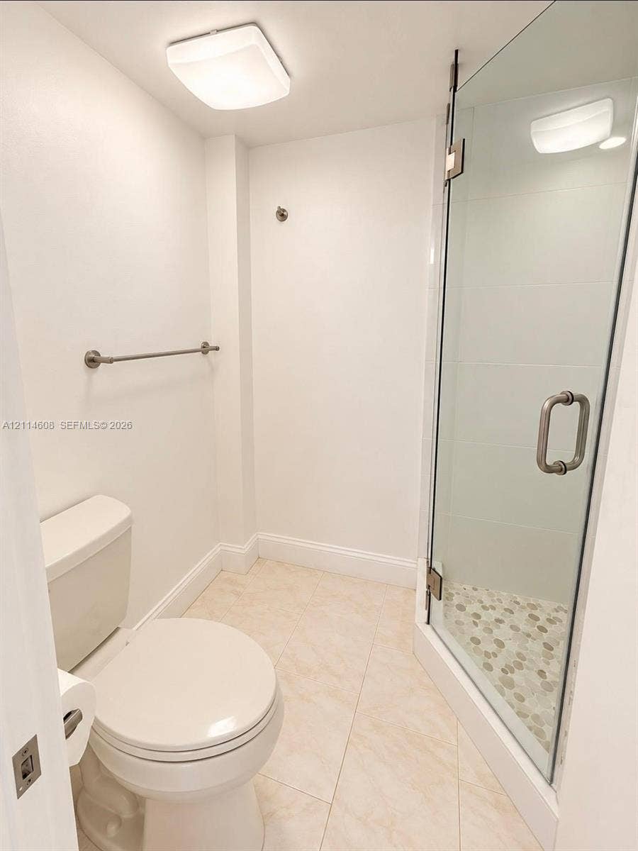 Bathroom featuring a glass-enclosed shower with pebble-stone flooring