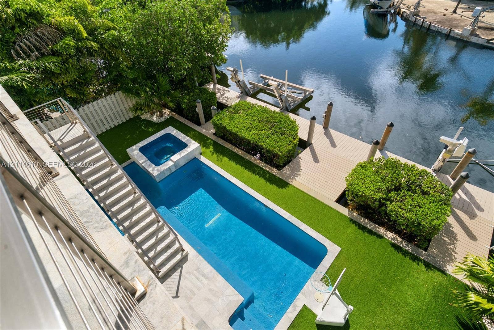 131 Ojibway Avenue, Islamorada, FL 33070 Waterfront patio featuring a private swimming pool with integrated spa, composite decking, artificial turf, and a private boat dock