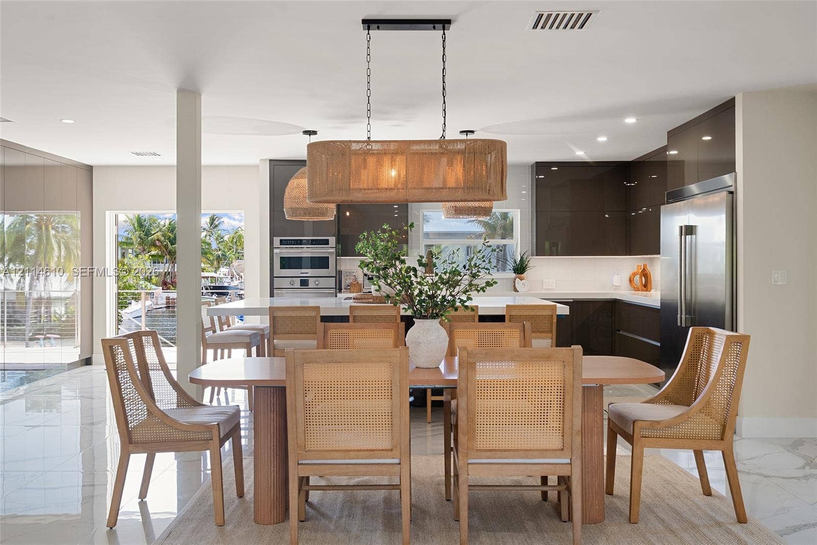 131 Ojibway Avenue, Islamorada, FL 33070 High-gloss cabinetry, stone-surfaced kitchen island, large-format tile flooring, stainless steel built-in appliances, and pendant lighting
