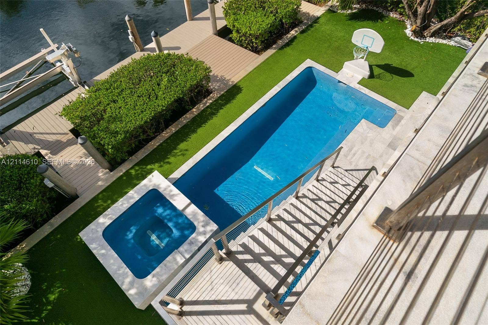 131 Ojibway Avenue, Islamorada, FL 33070 Waterfront property featuring a custom in-ground swimming pool, integrated spa, synthetic turf lawn, and a private composite dock