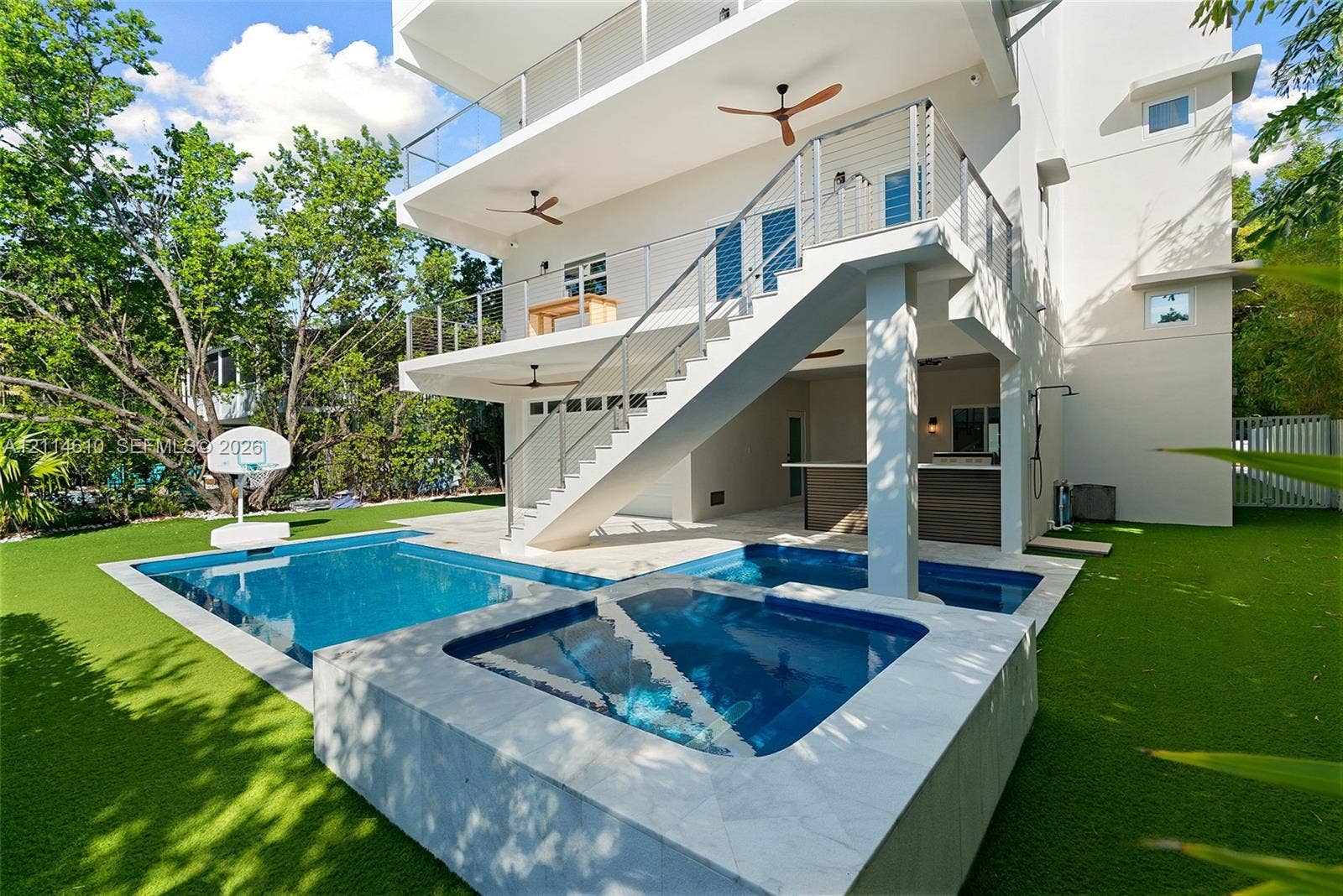 131 Ojibway Avenue, Islamorada, FL 33070 Multi-level exterior featuring a private swimming pool with integrated spa, covered outdoor kitchen with bar seating, and metal cable railing staircase
