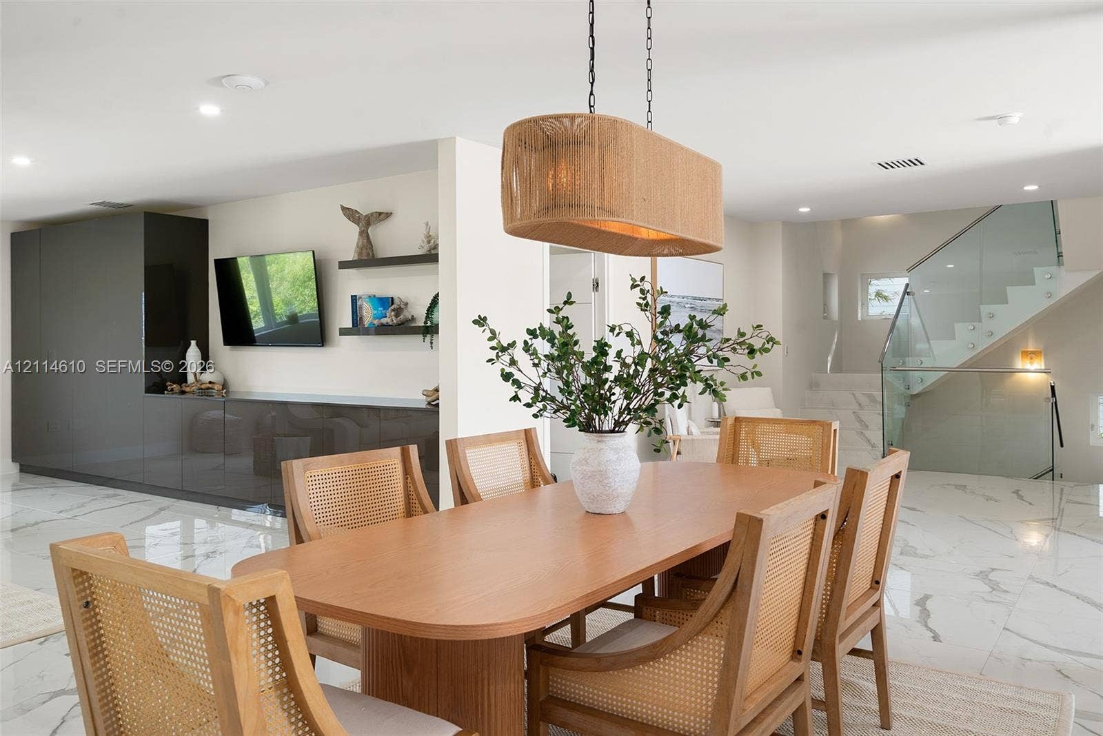 131 Ojibway Avenue, Islamorada, FL 33070 Large-format tile flooring, built-in charcoal cabinetry with integrated shelving, glass staircase railing, and a textured pendant light fixture