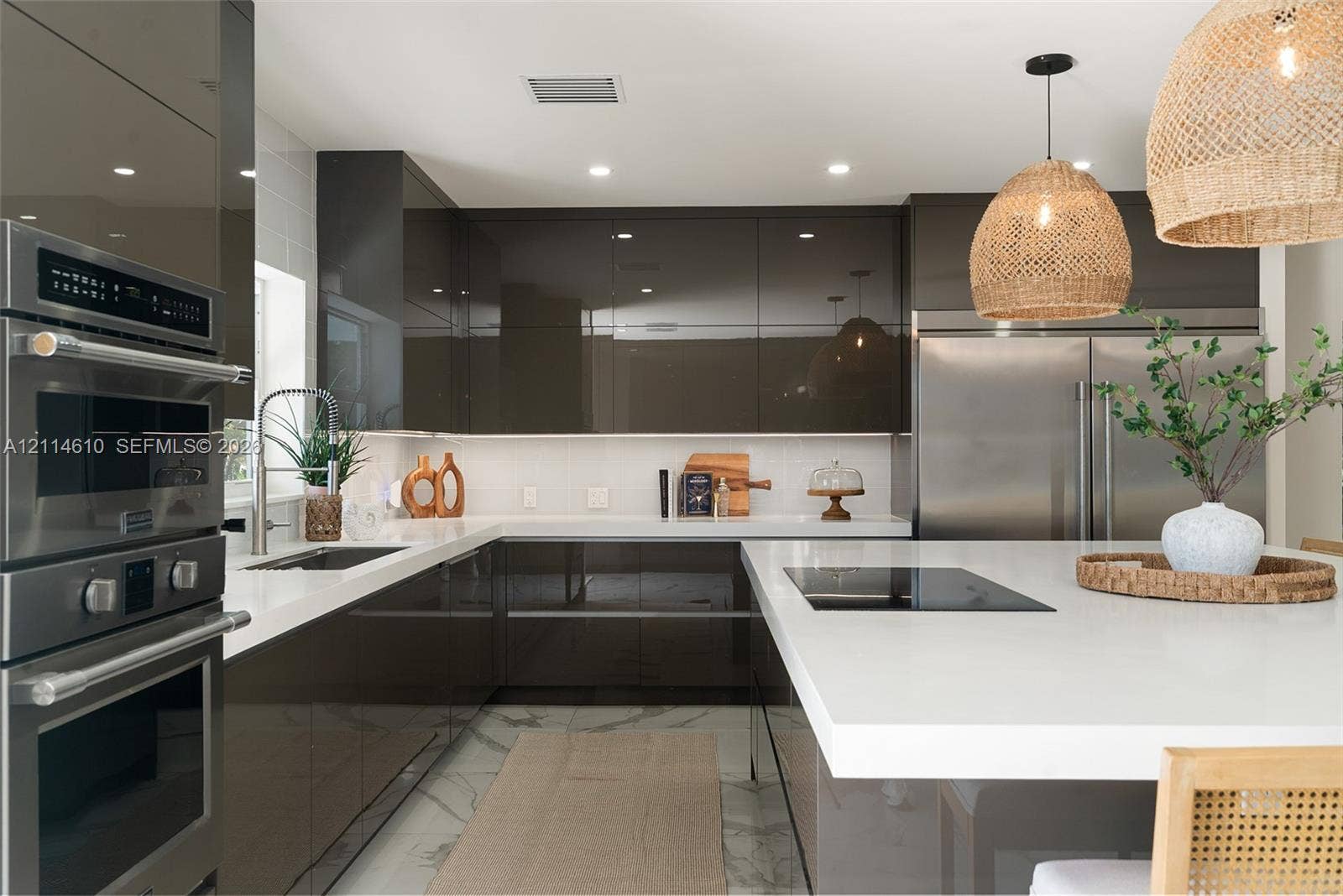 131 Ojibway Avenue, Islamorada, FL 33070 Kitchen featuring high-gloss cabinetry, stone-finish countertops, stainless steel wall ovens, a large center island with an integrated cooktop, and woven pendant lighting