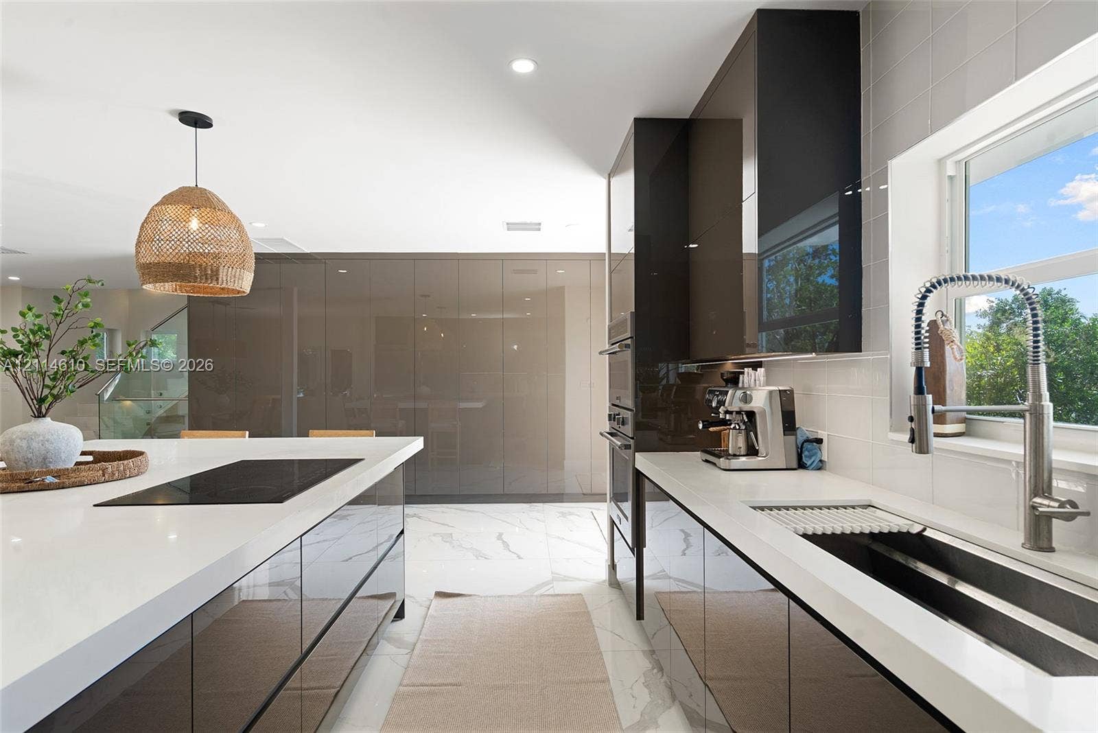 131 Ojibway Avenue, Islamorada, FL 33070 Kitchen featuring high-gloss cabinetry, stone-finish countertops, tile flooring with stone-vein detailing, stainless steel wall-mounted oven, and a gooseneck faucet