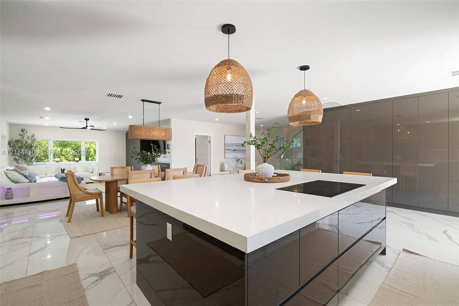 131 Ojibway Avenue, Islamorada, FL 33070 Large center island featuring a waterfall-edge quartz countertop, built-in induction cooktop, and glossy cabinetry