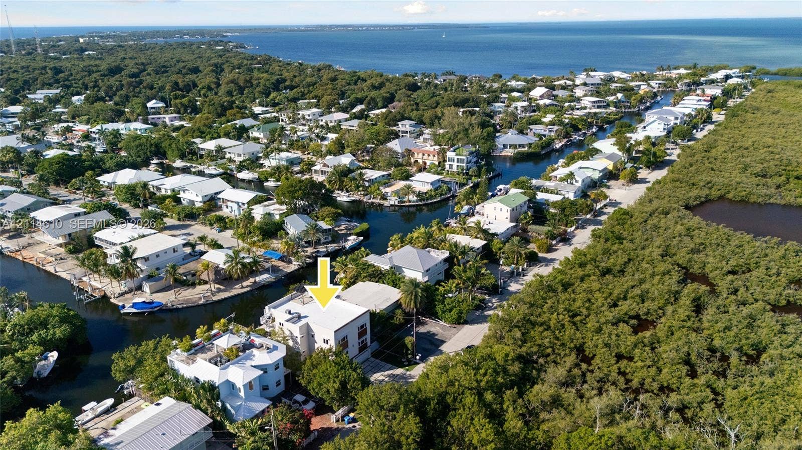 131 Ojibway Avenue, Islamorada, FL 33070 Aerial perspective of a multi-story property featuring a flat roof and proximity to a waterway canal system