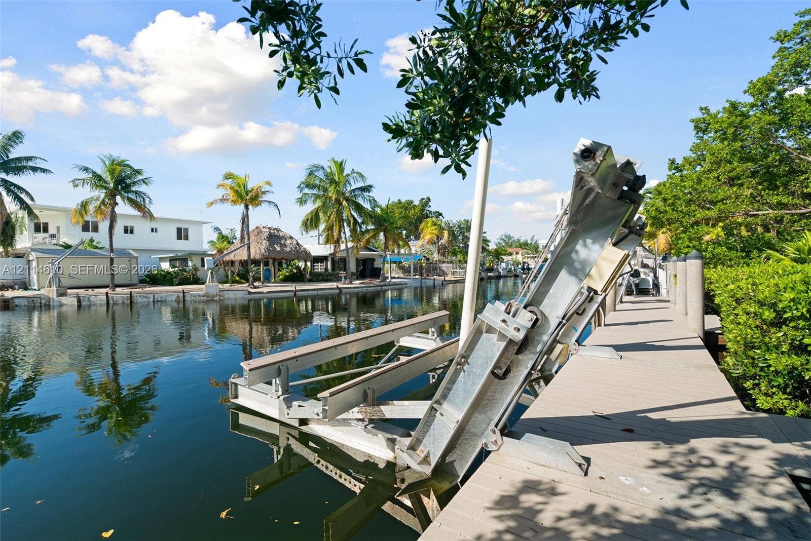 131 Ojibway Avenue, Islamorada, FL 33070 Waterfront bulkhead with a dedicated boat lift and a composite plank dock