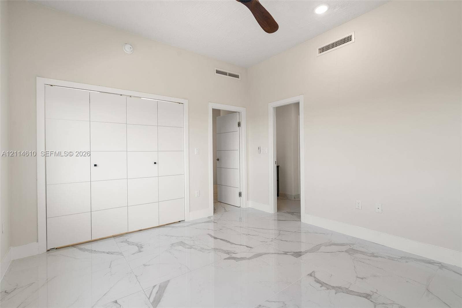 131 Ojibway Avenue, Islamorada, FL 33070 Room featuring large-format tile flooring with a veined finish, high ceilings, recessed lighting, a ceiling fan, and built-in closet cabinetry with panel detail