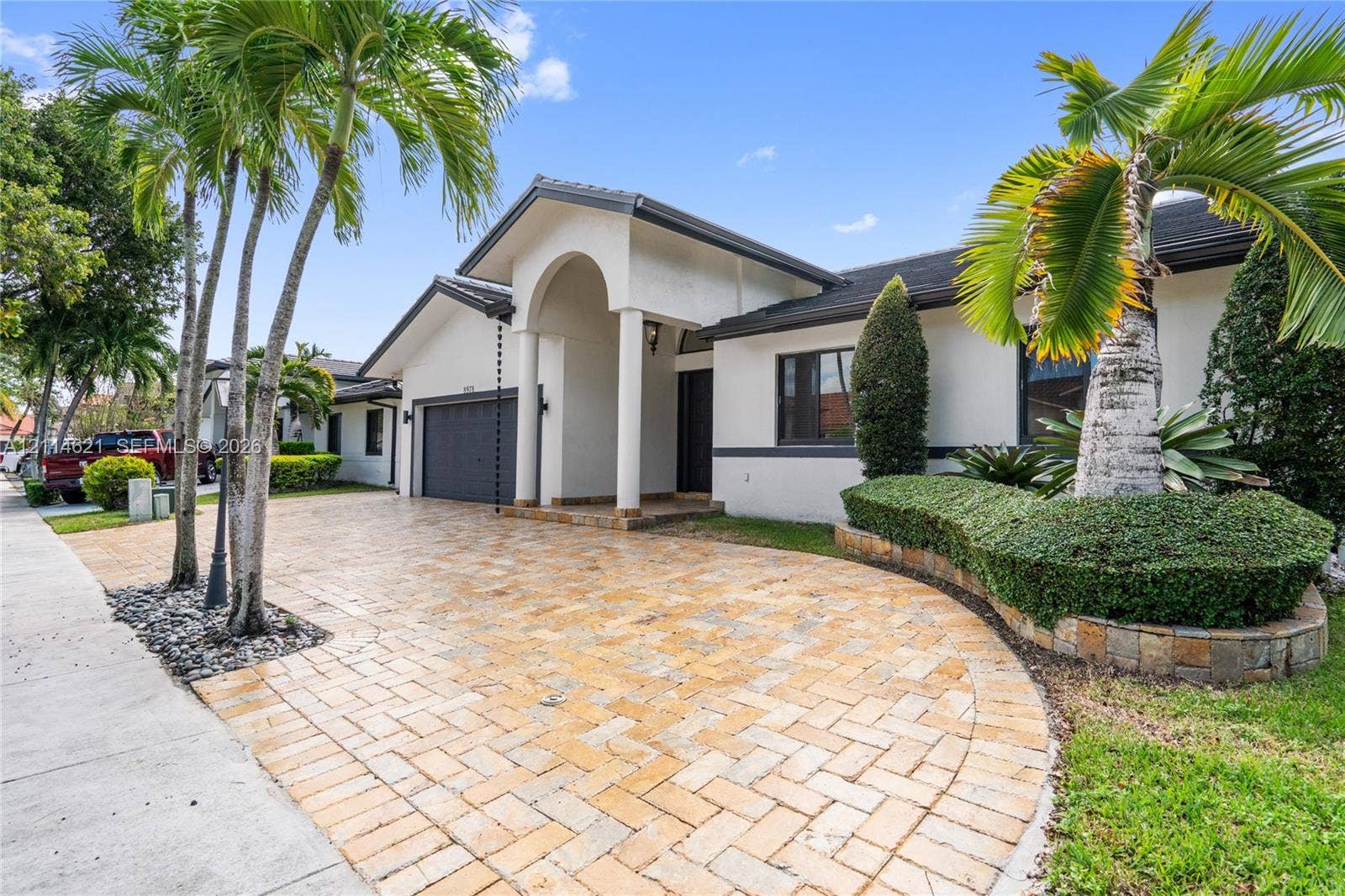 8978 NW 152nd Lane, #8978, Miami Lakes, Miami Lakes, FL 33018 Stucco exterior featuring an arched entryway, a stone-paver driveway, and an attached multi-car garage