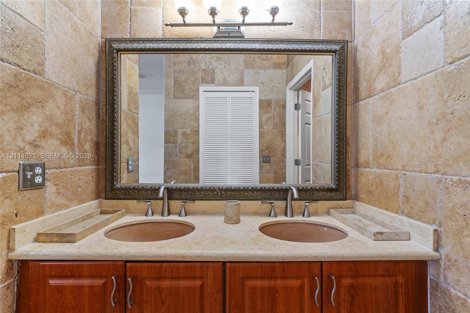 8978 NW 152nd Lane, #8978, Miami Lakes, Miami Lakes, FL 33018 Dual-sink vanity with a stone countertop, wood cabinetry, stone tile wall cladding, and a large framed mirror