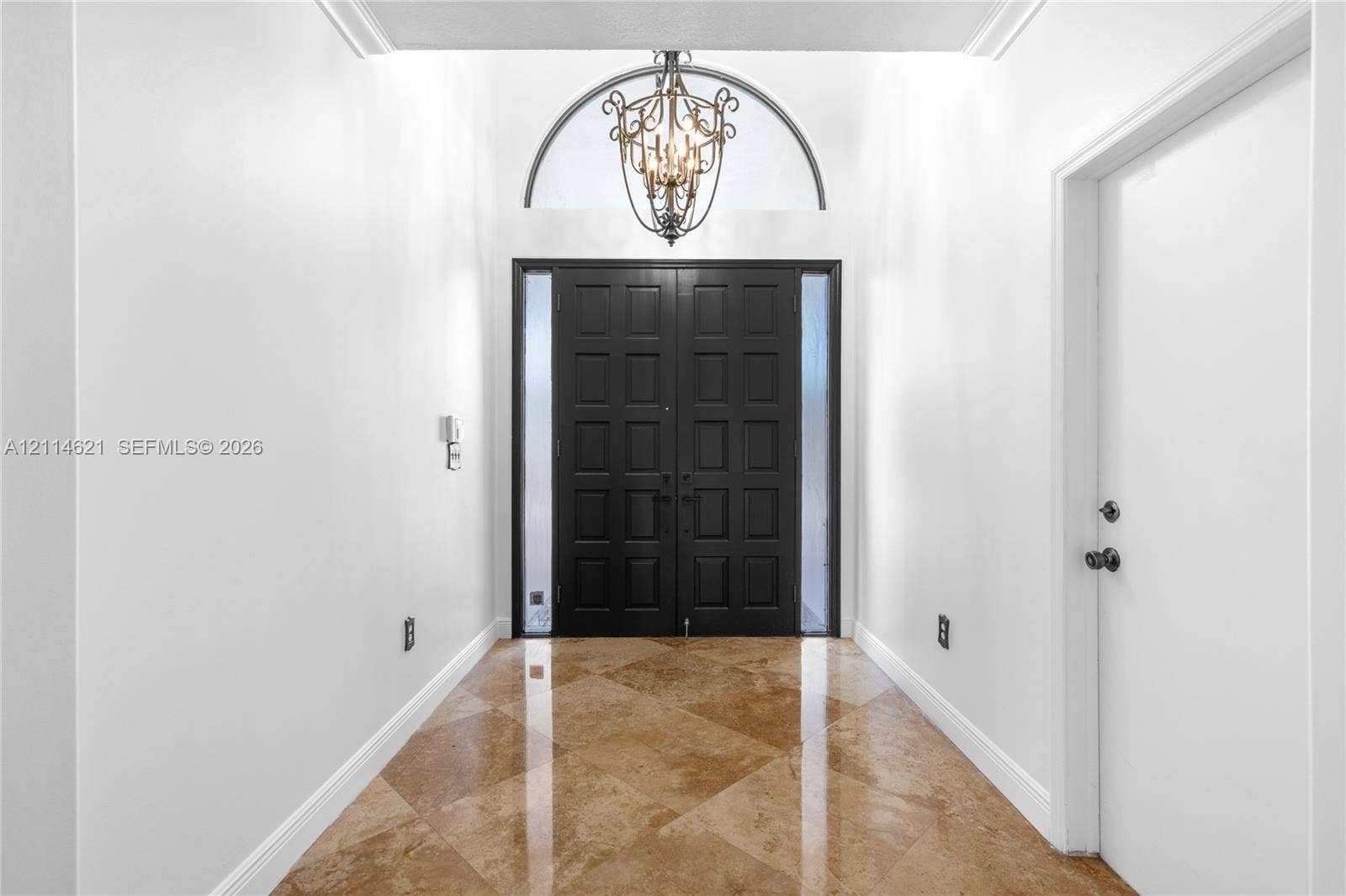 8978 NW 152nd Lane, #8978, Miami Lakes, Miami Lakes, FL 33018 Foyer featuring double entry doors with vertical glass sidelights, an arched transom window, a multi-tiered metal chandelier, and diagonal-set stone-finish flooring