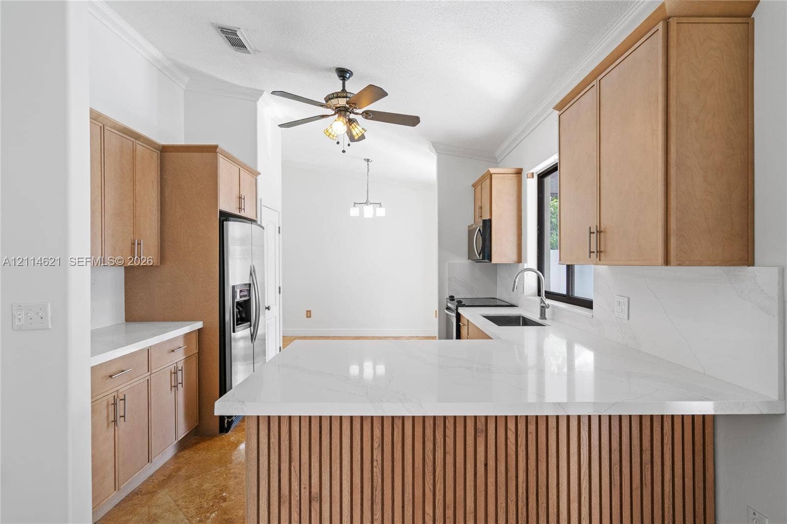 8978 NW 152nd Lane, #8978, Miami Lakes, Miami Lakes, FL 33018 Kitchen featuring flat-panel wood cabinetry, white stone-finish countertops, slatted wood kitchen island detailing, stainless steel appliances, and a mounted ceiling fan