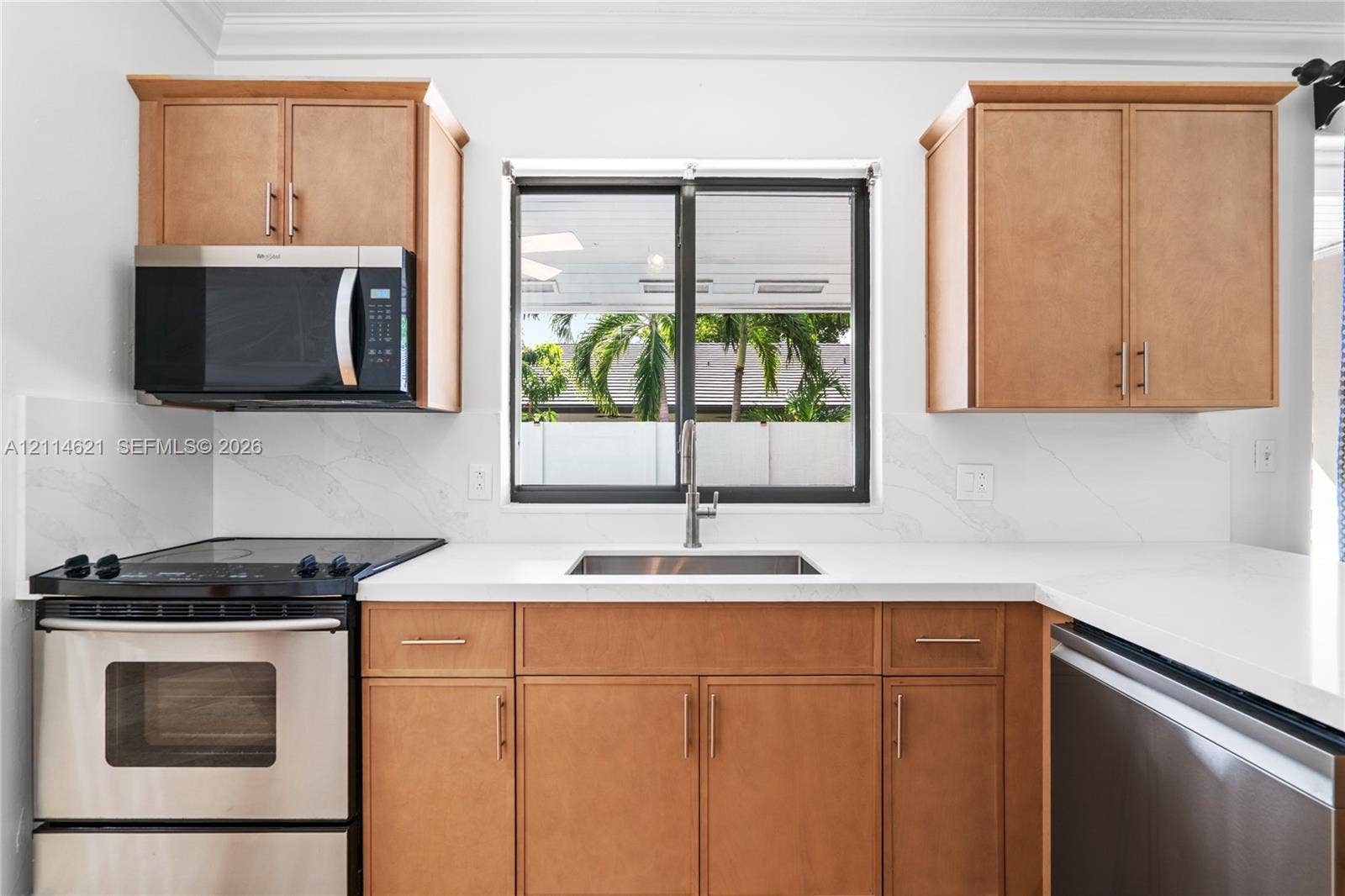 8978 NW 152nd Lane, #8978, Miami Lakes, Miami Lakes, FL 33018 Kitchen featuring wood-finish cabinetry, solid surface countertops, a stainless steel undermount sink, matching stainless steel appliances, and a single-handle pull-down faucet