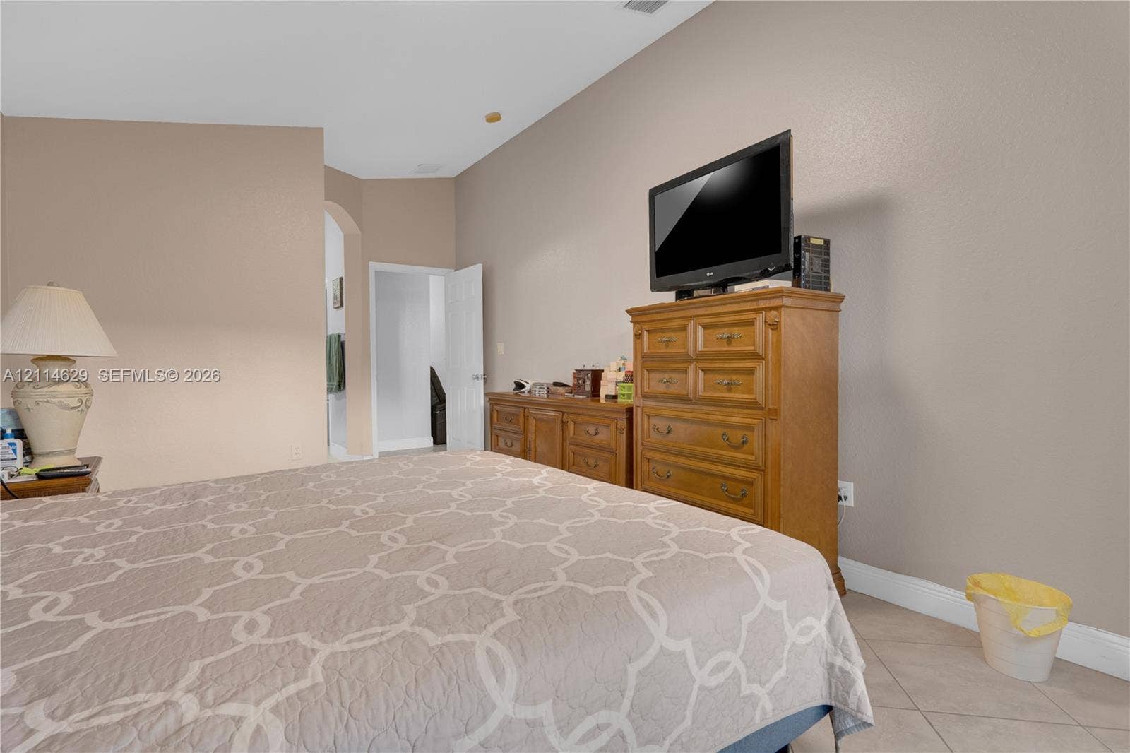 Vaulted ceilings and neutral-toned interior walls featuring a prominent arched doorway