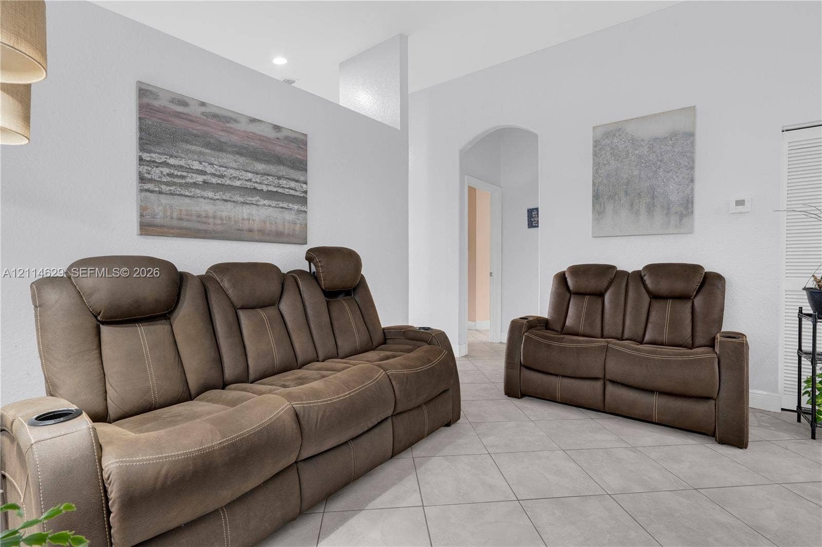 Neutral-toned ceramic tile flooring, arched doorway, and recessed ceiling lighting