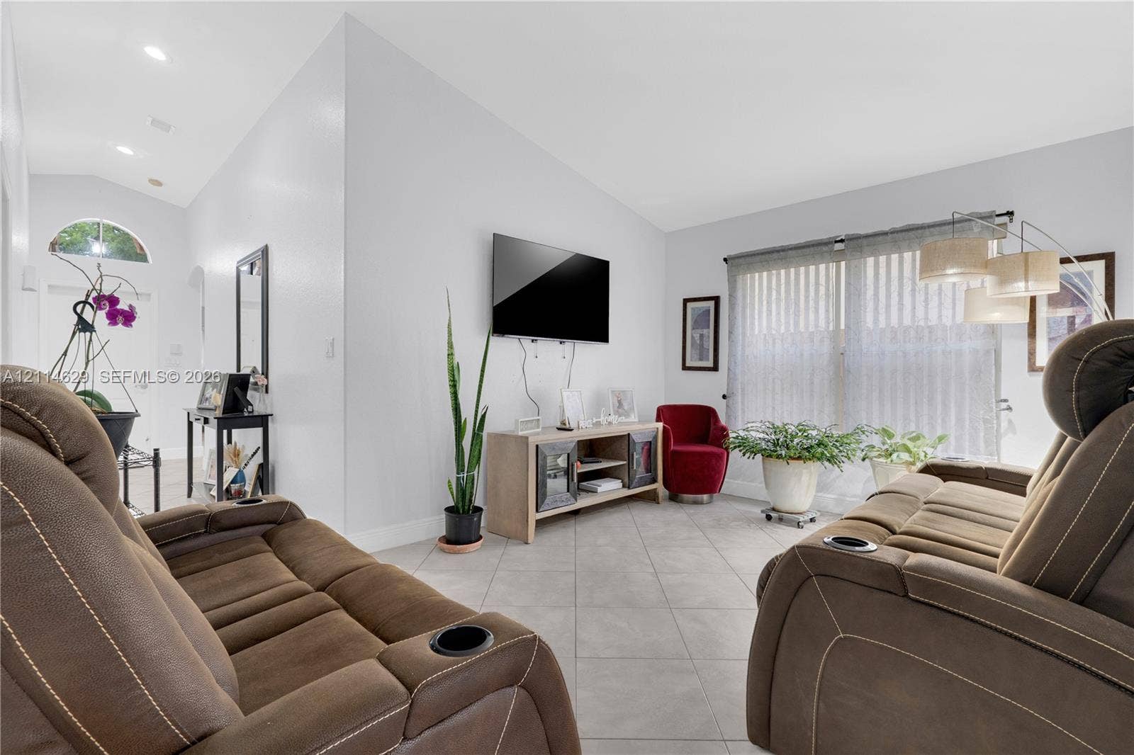 Vaulted ceilings, large-format tile flooring, recessed lighting, and expansive windows