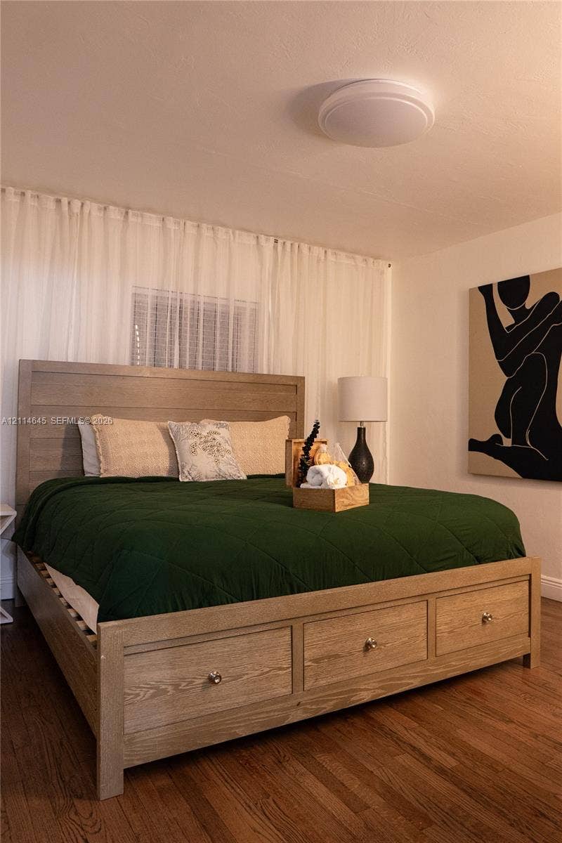 Room featuring wood-finish flooring and a flush-mount dome ceiling light