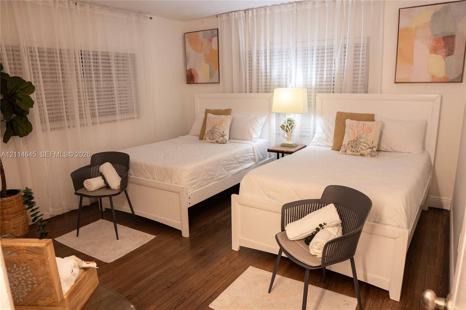 Neutral-toned interior featuring wood-finish flooring, white window blinds, and sheer floor-to-ceiling drapery