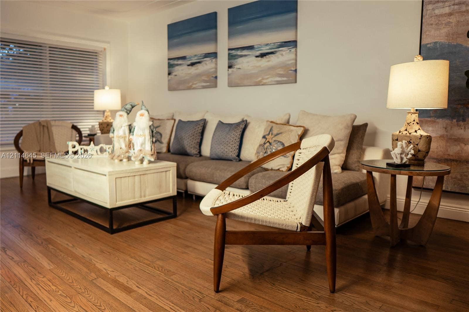 Living area featuring wood-finish flooring and horizontal blind window treatments