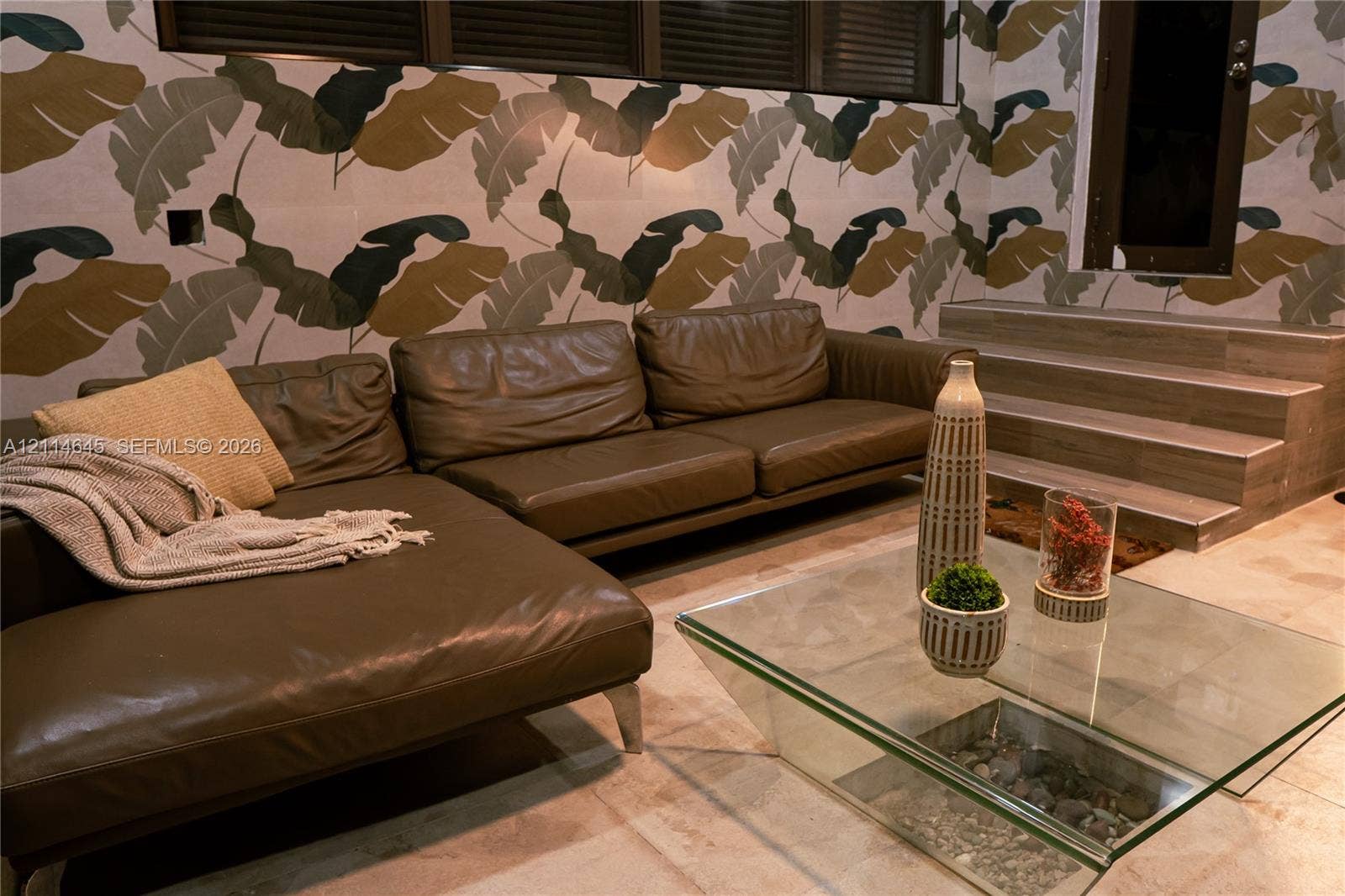 Large-format patterned wall coverings, stone-finish tile flooring, and integrated stone-surfaced stairs