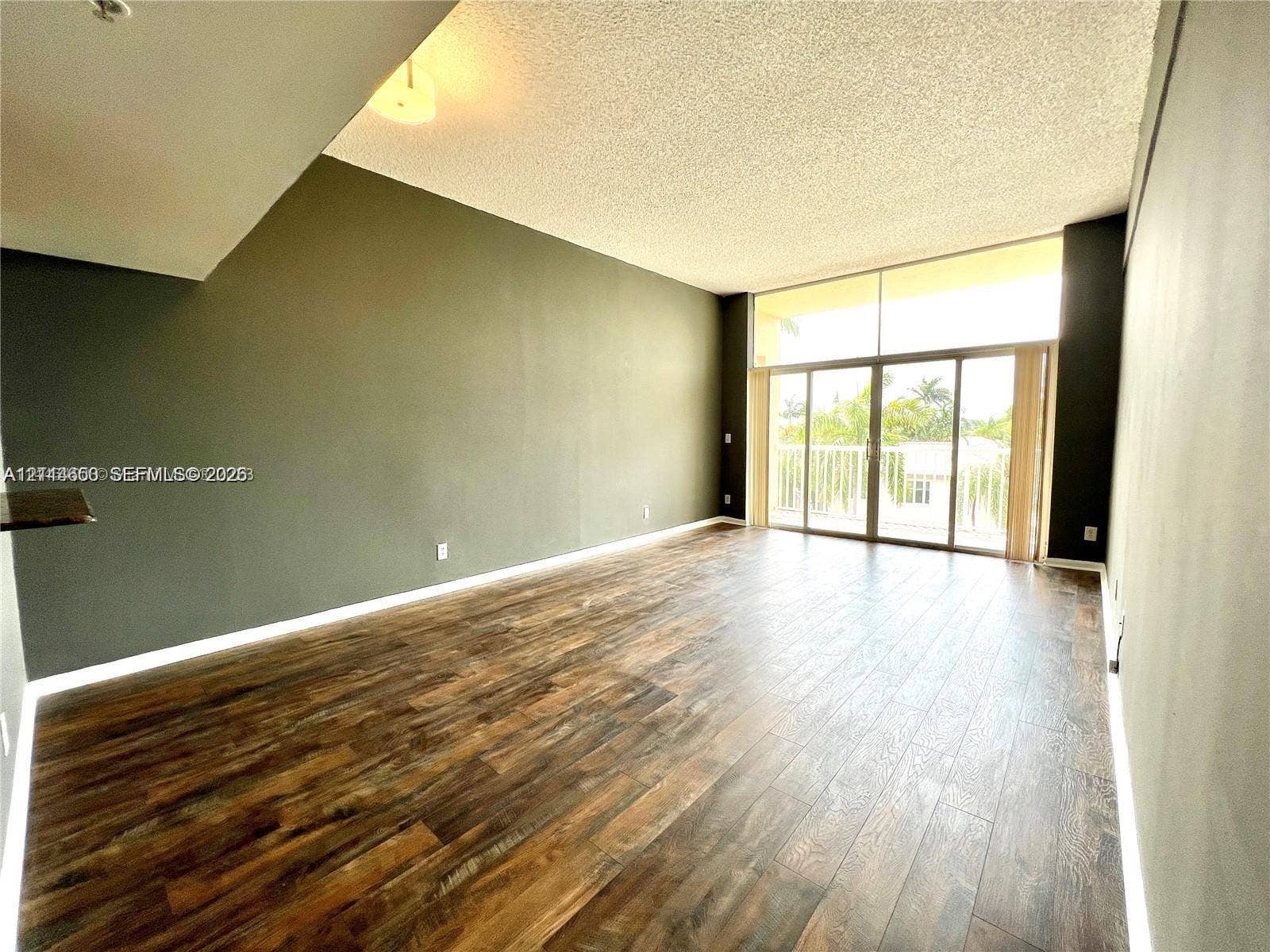 1450 SE 3rd Avenue, #411, Dania, Dania Beach, FL 33004 Living area featuring wood-finish flooring, floor-to-ceiling glass windows, and sliding glass doors leading to an exterior balcony