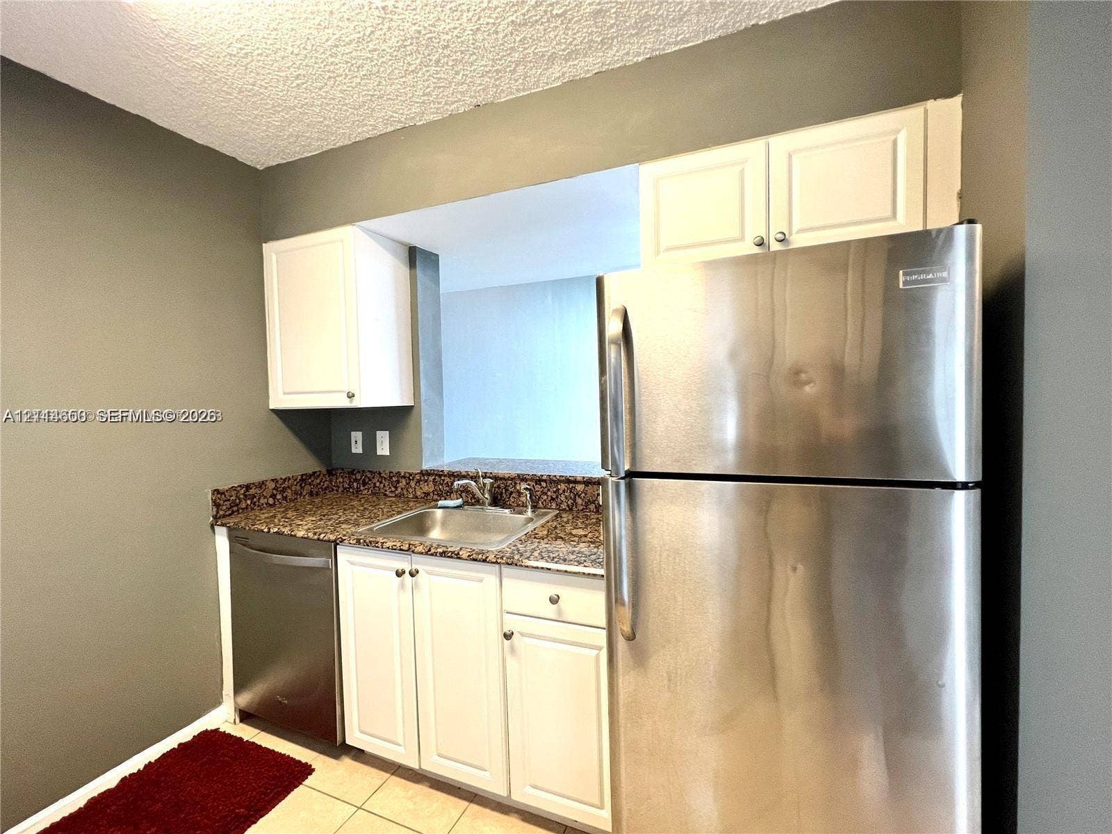 1450 SE 3rd Avenue, #411, Dania, Dania Beach, FL 33004 Kitchen featuring white cabinetry, stone-surface countertops, stainless steel refrigerator, stainless steel dishwasher, and a dual-basin stainless steel sink