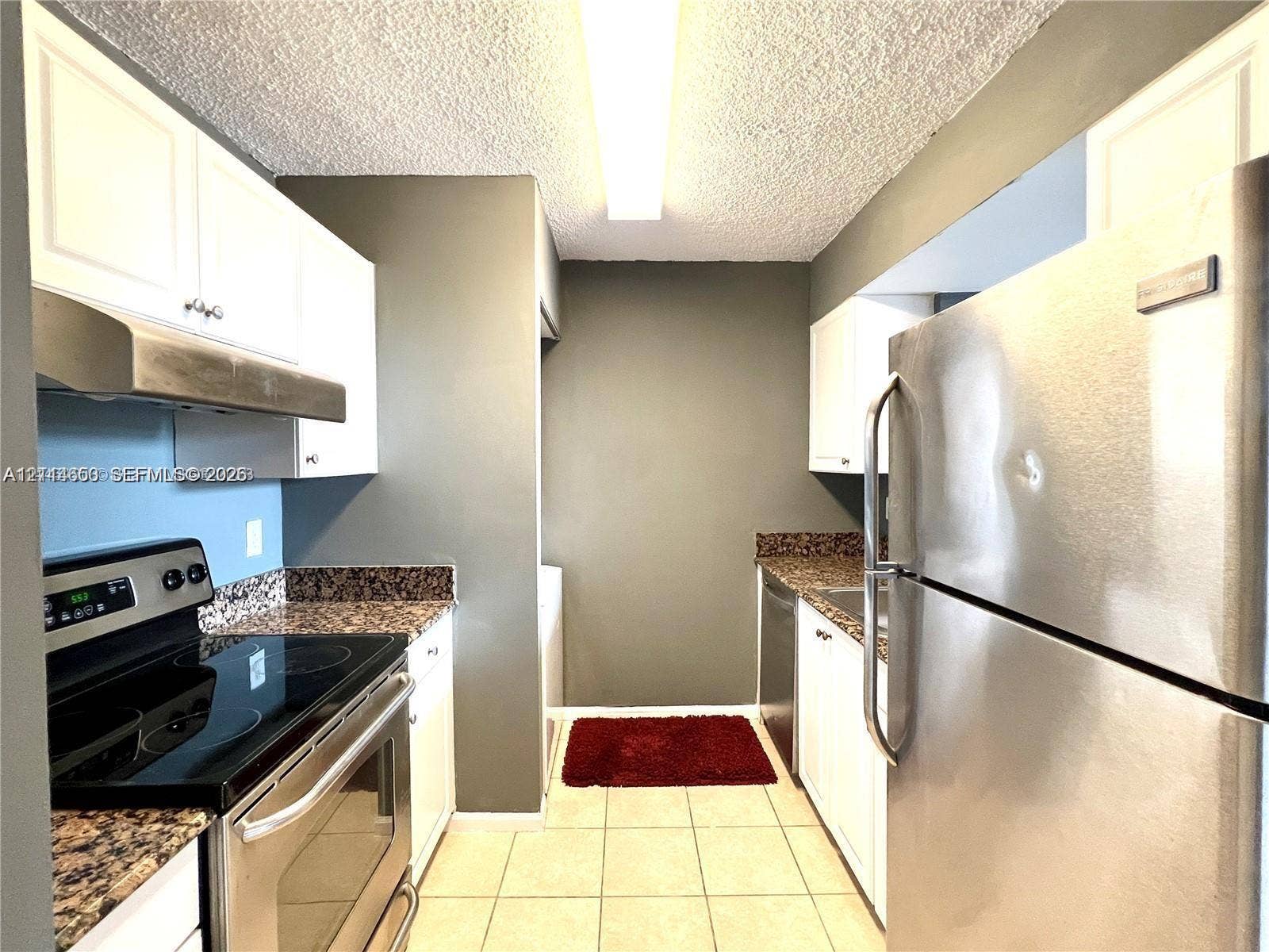1450 SE 3rd Avenue, #411, Dania, Dania Beach, FL 33004 Kitchen featuring white cabinetry, stone-finish countertops, stainless steel appliances, and tile flooring