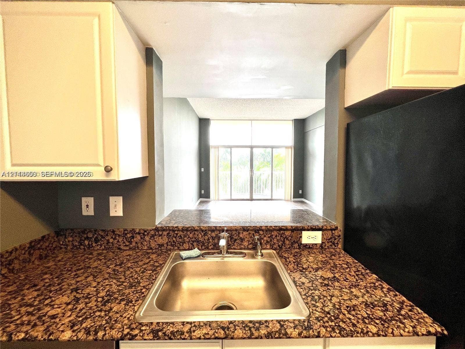 1450 SE 3rd Avenue, #411, Dania, Dania Beach, FL 33004 Kitchen featuring stone-finish countertops, stainless steel undermount sink, white cabinetry, and a black refrigerator