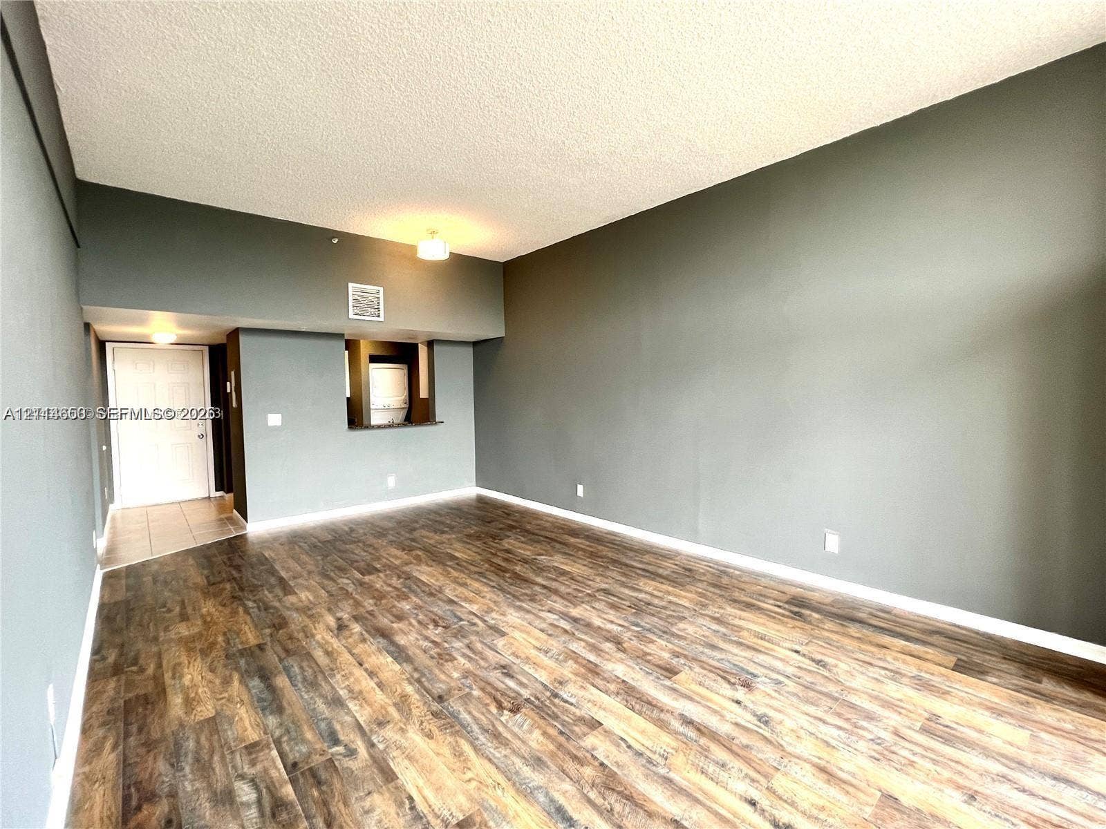 1450 SE 3rd Avenue, #411, Dania, Dania Beach, FL 33004 Interior space featuring wood-finish flooring, vaulted ceilings, and a pass-through opening to the kitchen
