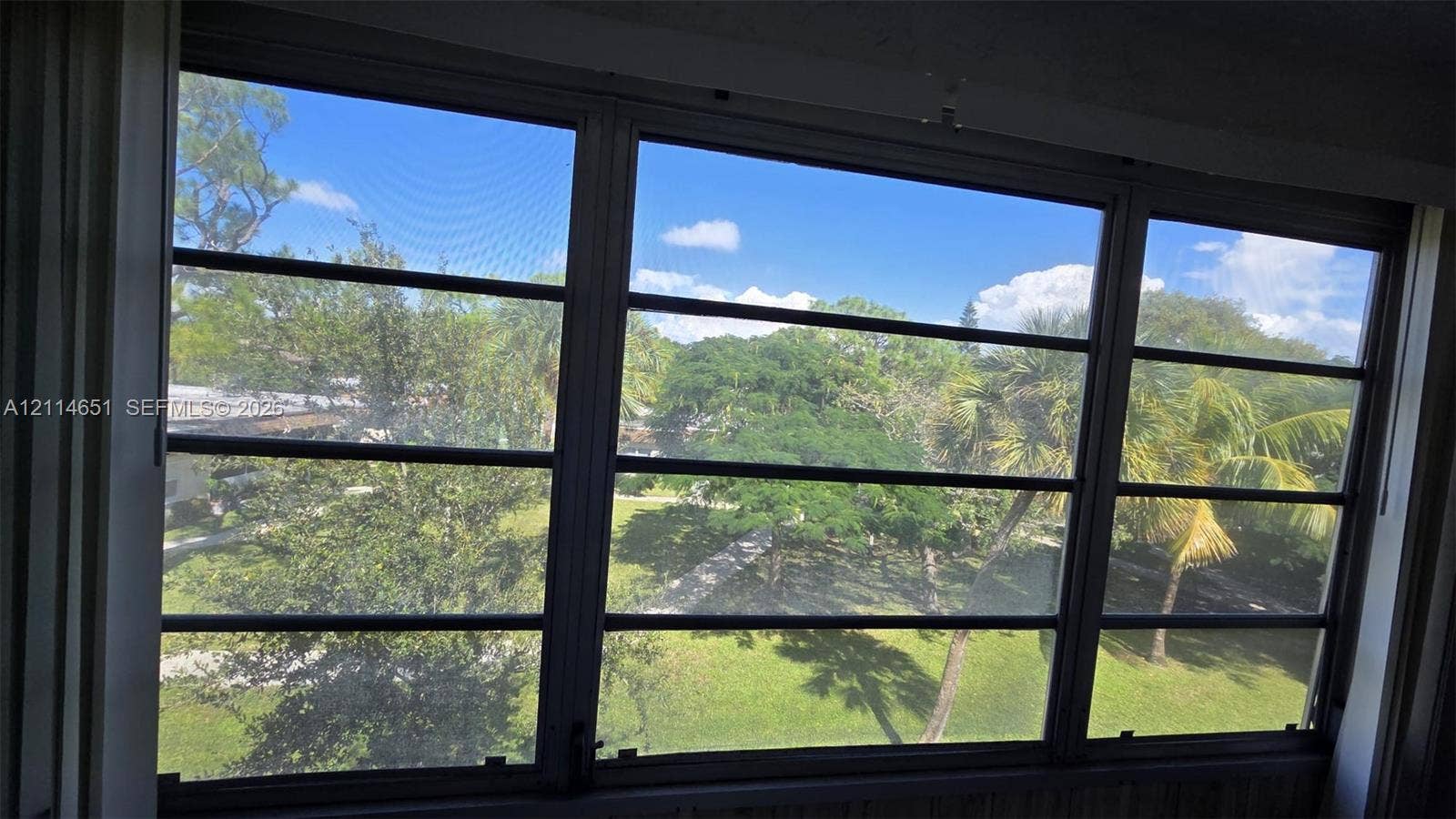 Multi-pane horizontal sliding windows with dark metal frames and screening