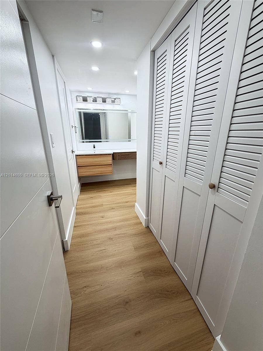 3301 N Country Club Drive, #507, Aventura, Aventura, FL 33180 Wood-finish flooring, dual-door louvered closets, wall-mounted floating vanity, and integrated vanity lighting
