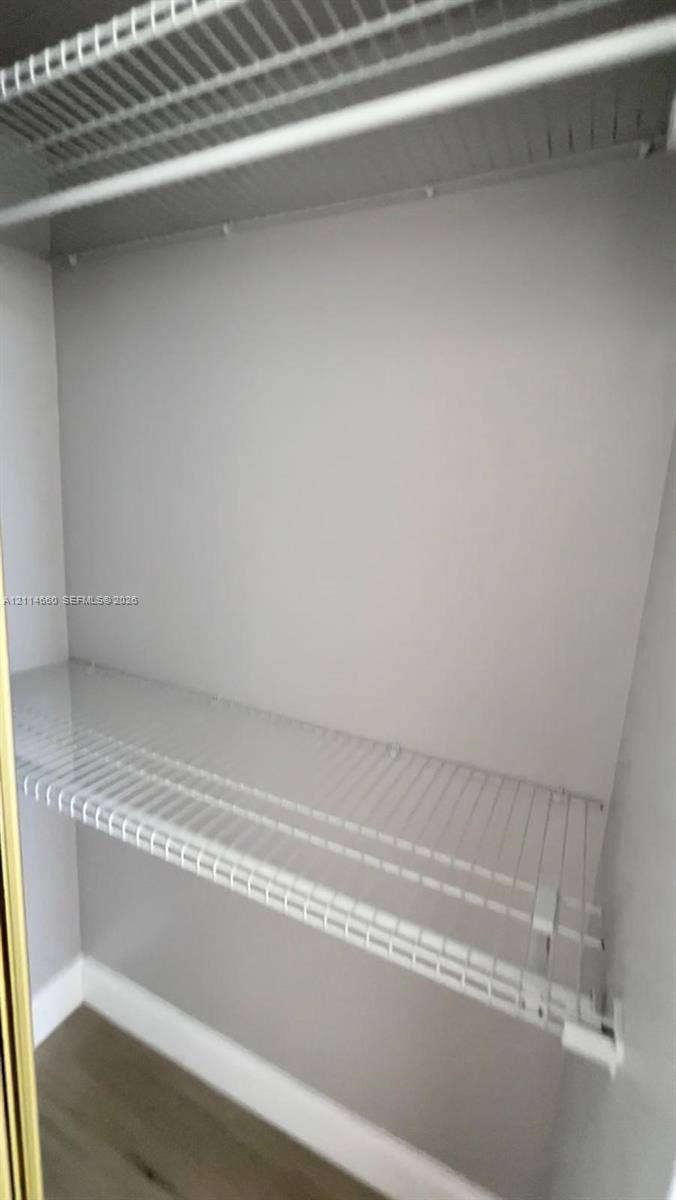 Closet featuring white wire shelving and wood-finish flooring