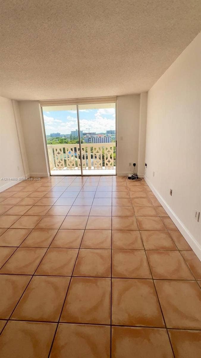 Ceramic tile flooring, sliding glass balcony door, and exterior balcony with decorative railing