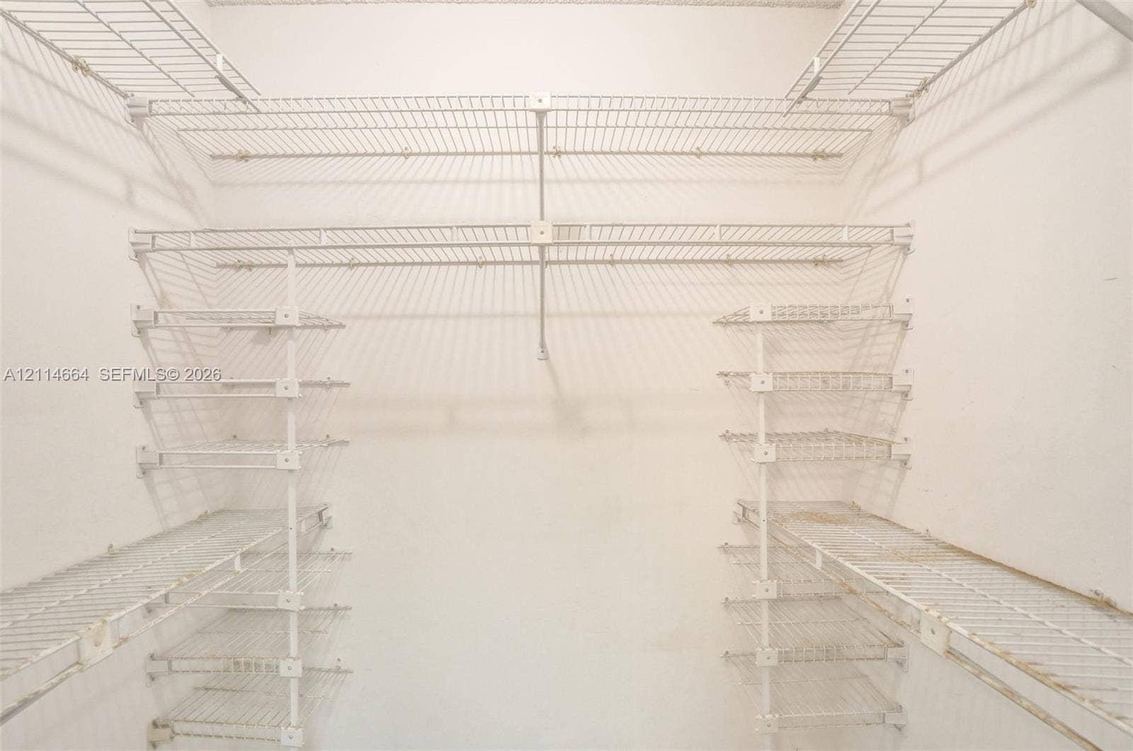 11164 NW 10th Place, Coral Springs, FL 33071 Walk-in storage area featuring white wire shelving units with multi-level hanging rods and integrated shelf tiers