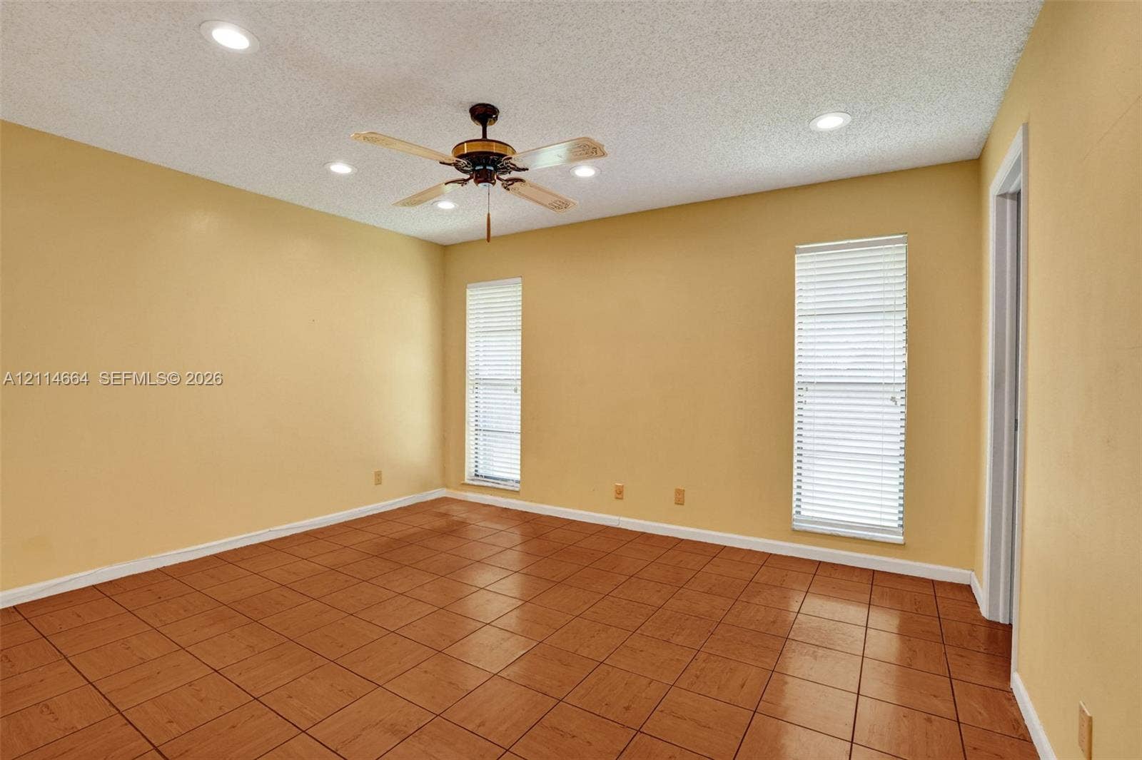 11164 NW 10th Place, Coral Springs, FL 33071 Ceramic tile flooring, recessed lighting, and a ceiling fan with integrated lighting, finished with two windows featuring horizontal blinds