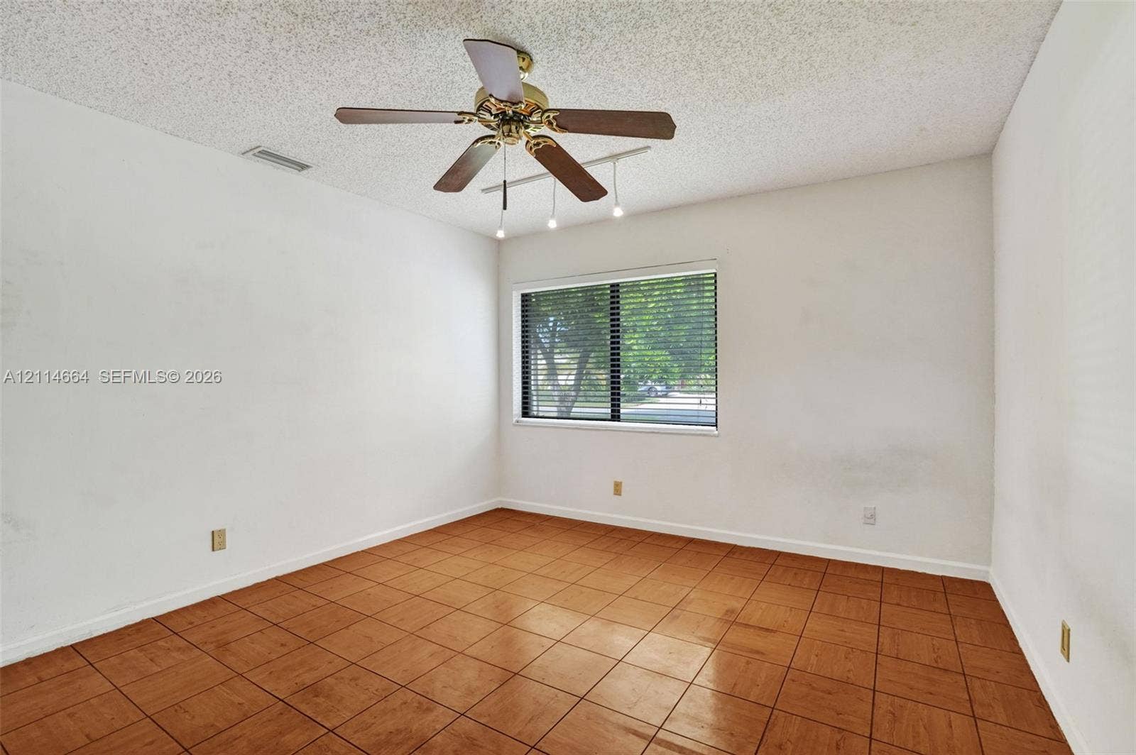 11164 NW 10th Place, Coral Springs, FL 33071 Interior room featuring ceramic tile flooring, a multi-blade ceiling fan with integrated lighting, and a window with horizontal blinds