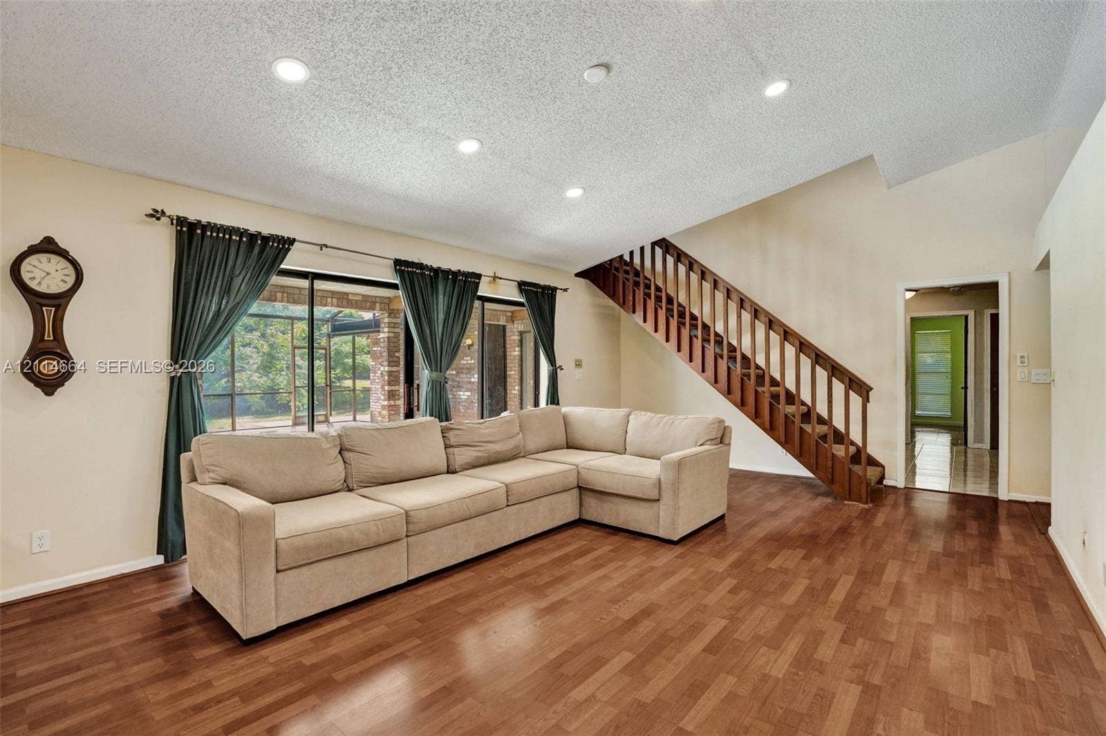 11164 NW 10th Place, Coral Springs, FL 33071 Vaulted ceilings with recessed lighting, wood-finish flooring, and a wooden staircase featuring open-riser styling and railings