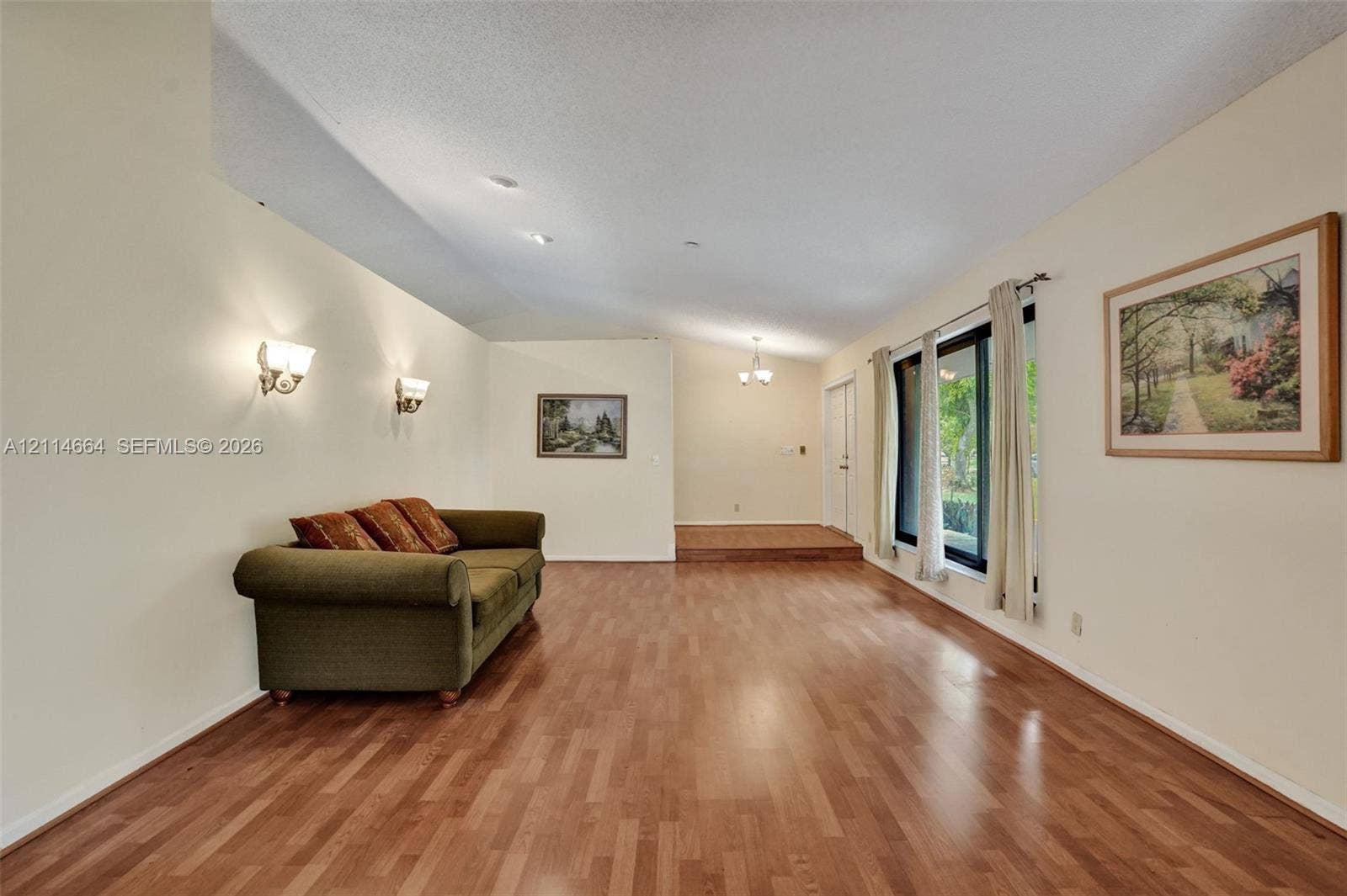 11164 NW 10th Place, Coral Springs, FL 33071 Wood-finish flooring, vaulted ceilings, wall-mounted light fixtures, and expansive windows