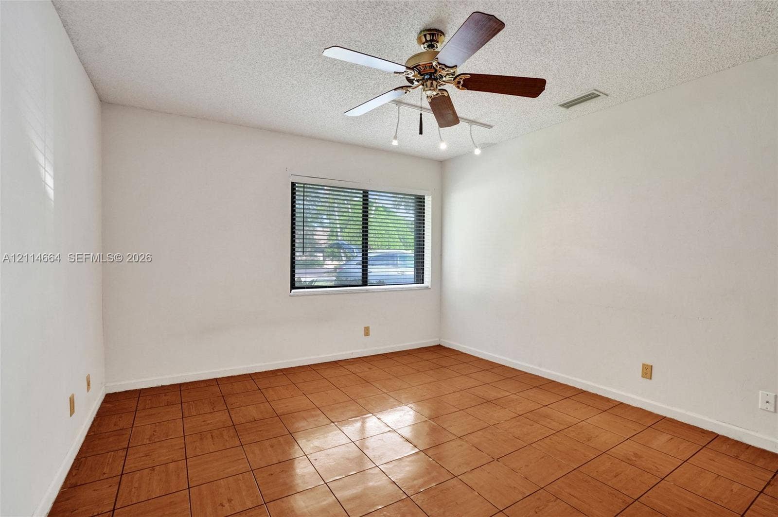 11164 NW 10th Place, Coral Springs, FL 33071 Room featuring ceramic tile flooring, a multi-blade ceiling fan with integrated lighting, and a single-pane window with horizontal blinds