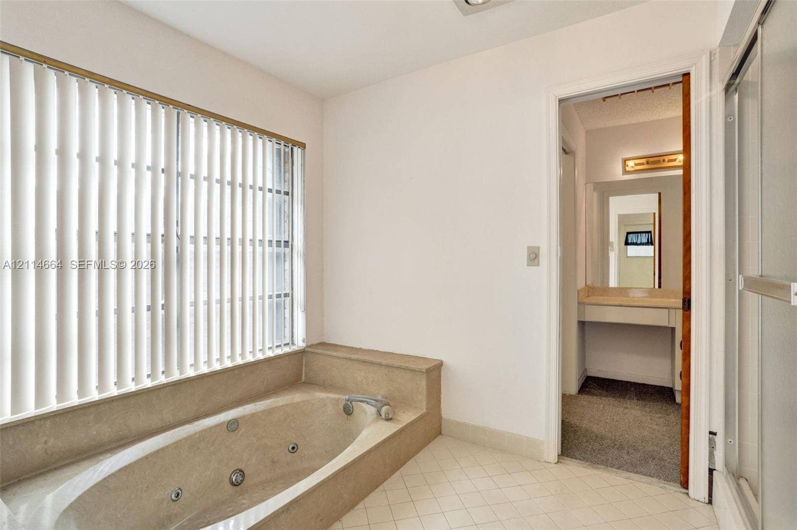 11164 NW 10th Place, Coral Springs, FL 33071 Jetted soaking tub with tile surround, window featuring vertical blinds, ceramic tile flooring, and glass-enclosed shower