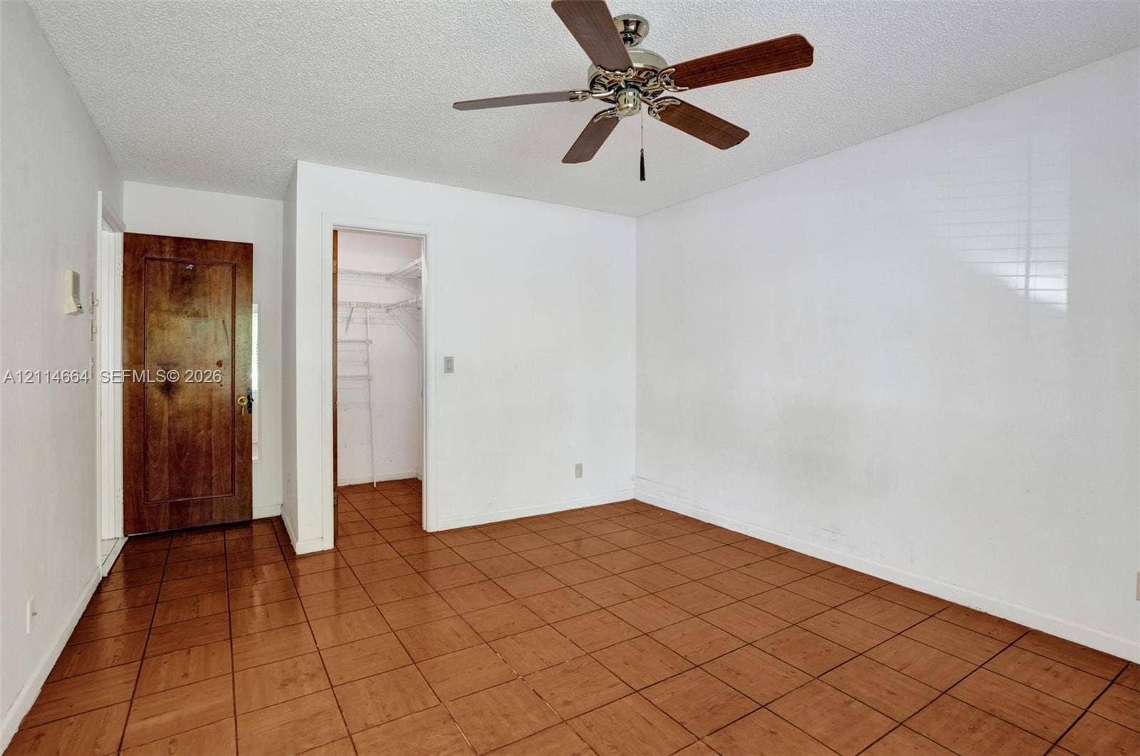 11164 NW 10th Place, Coral Springs, FL 33071 Interior room featuring ceramic tile flooring, a ceiling fan with integrated lighting, and a solid wood door