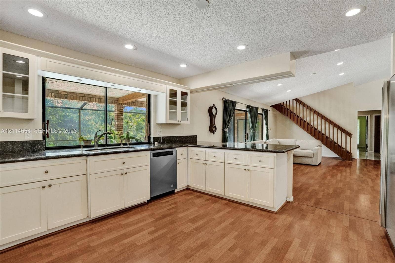 11164 NW 10th Place, Coral Springs, FL 33071 Kitchen featuring off-white cabinetry, dark stone countertops, recessed lighting, wood-finish flooring, and a stainless steel dishwasher