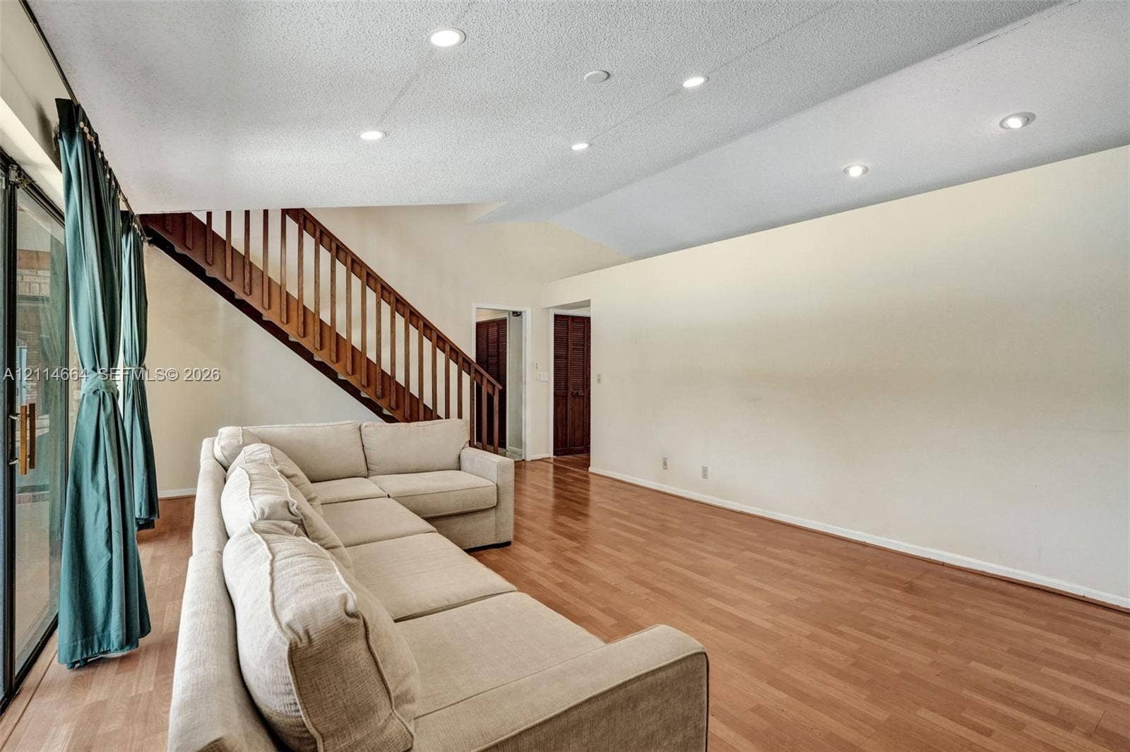 11164 NW 10th Place, Coral Springs, FL 33071 Vaulted ceilings, wood-finish flooring, recessed lighting, and a wooden staircase with vertical railing