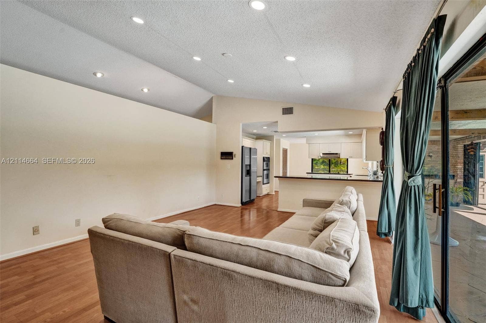 11164 NW 10th Place, Coral Springs, FL 33071 Vaulted ceilings with recessed lighting, wood-finish flooring, and sliding glass doors