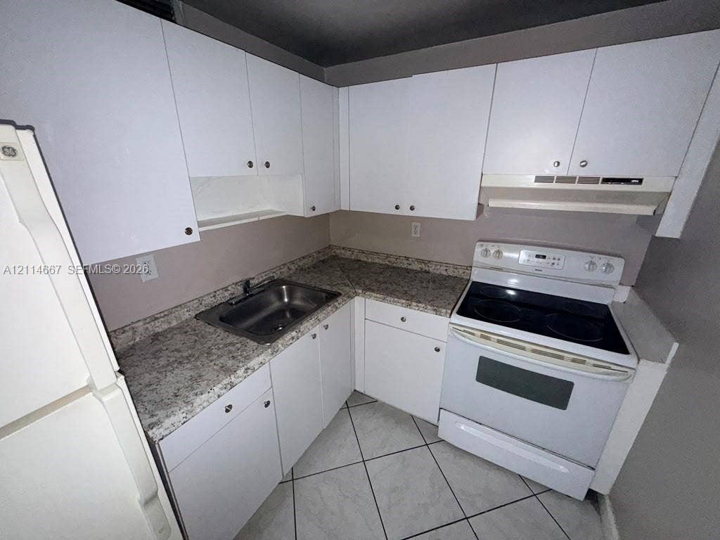 Kitchen featuring white cabinetry, stone-finish countertops, stainless steel sink, electric range, and tile flooring