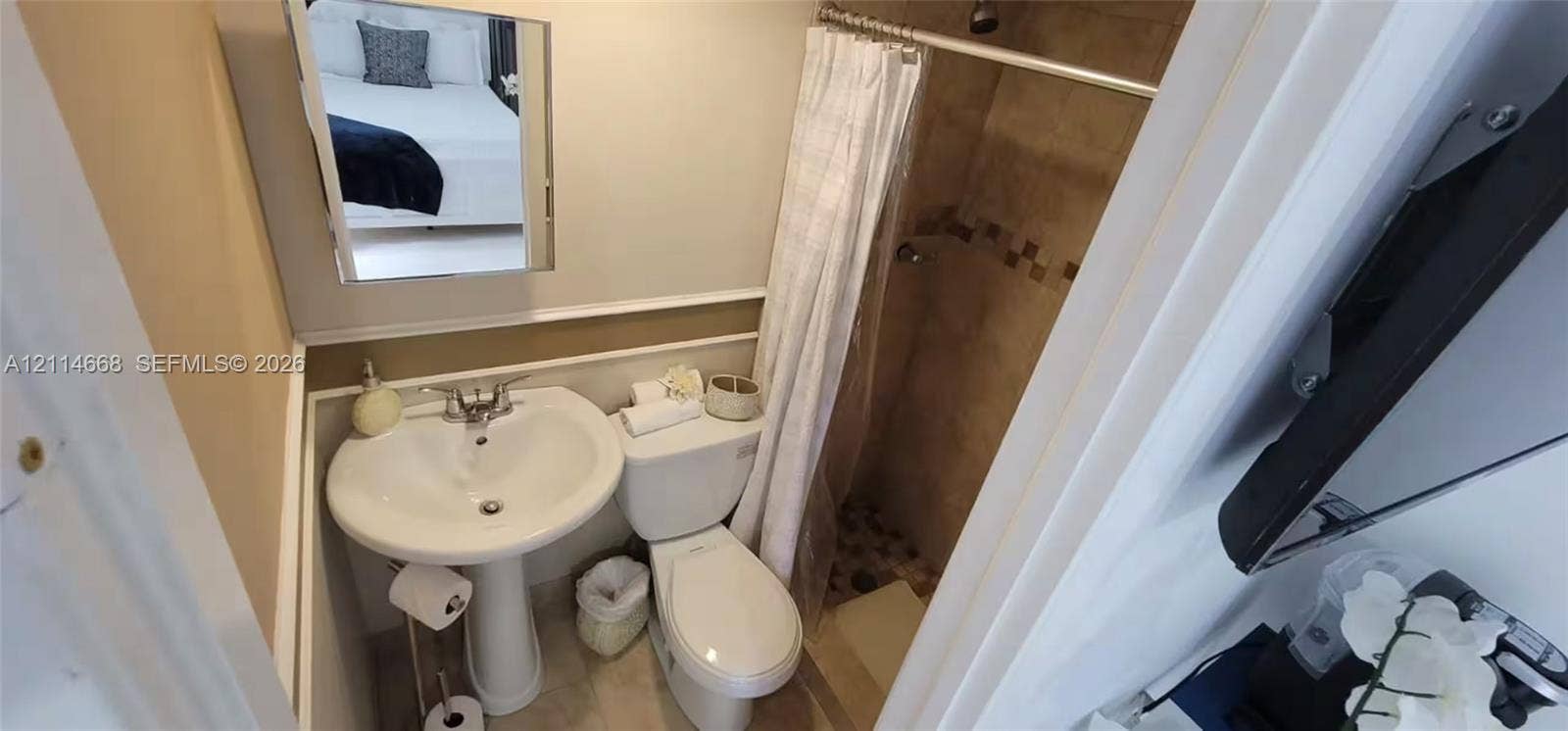 35 SW 28th Road, #B, Miami, Miami, FL 33129 Bathroom featuring a pedestal sink, wall-mounted mirror, white toilet, and a tiled shower stall