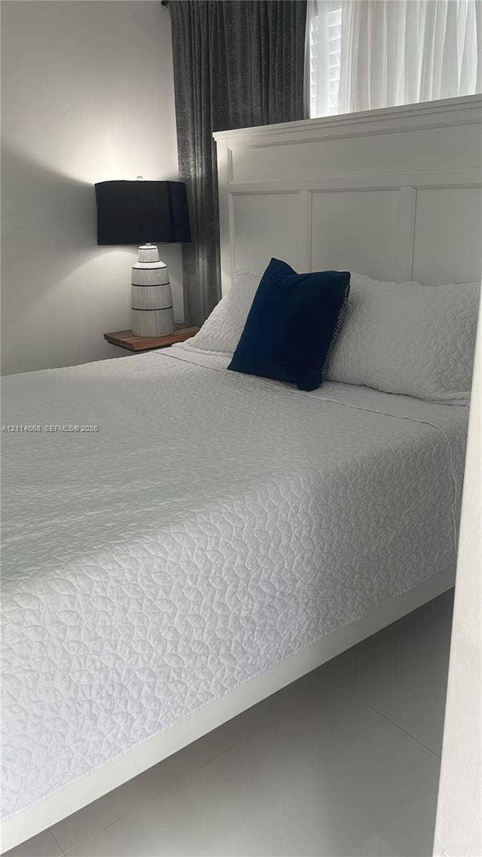 35 SW 28th Road, #B, Miami, Miami, FL 33129 Wall-mounted floating wooden bedside shelf, white panel-style headboard, and smooth tile flooring