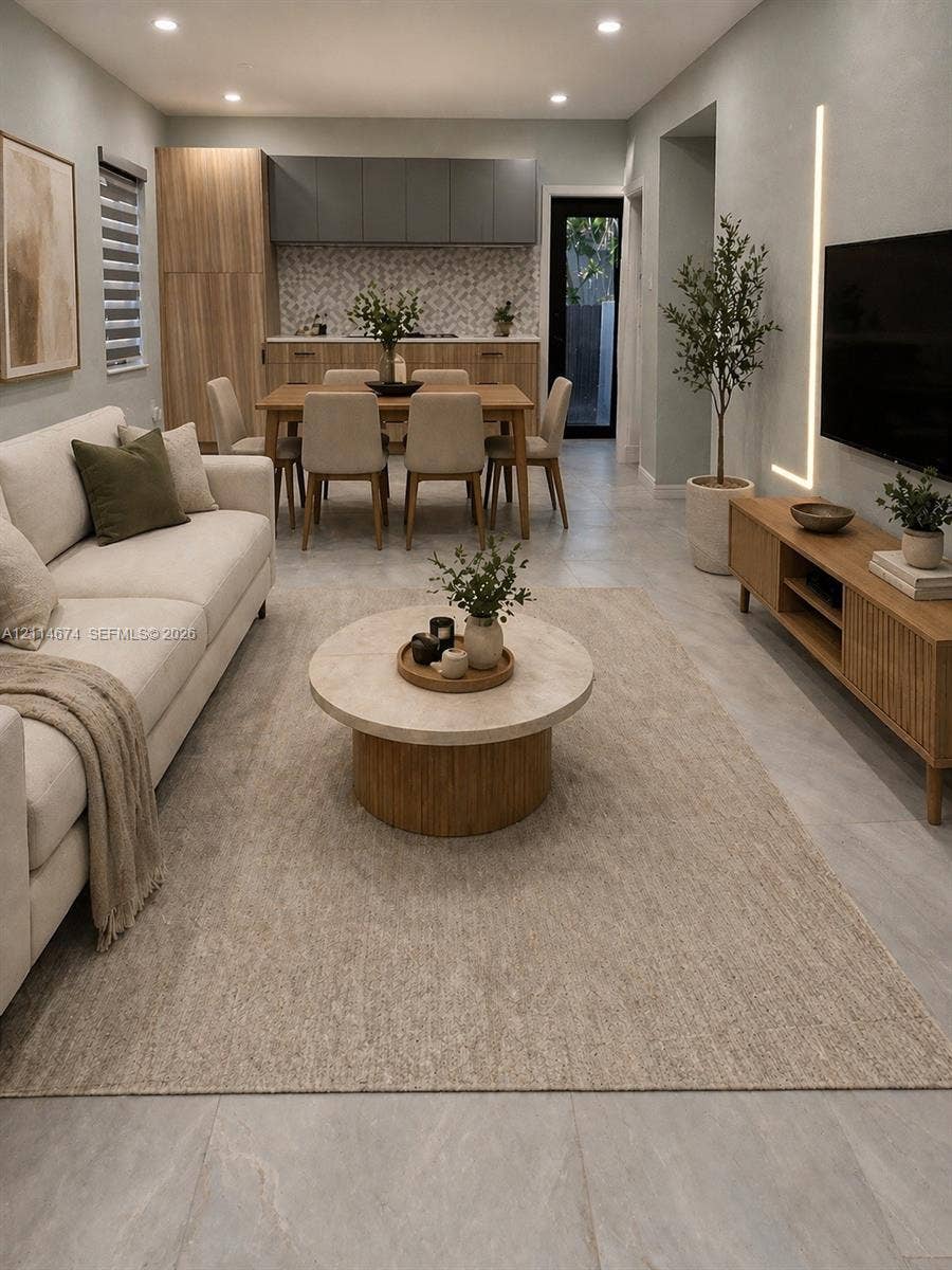 423 NW 32nd Place, Miami, Miami, FL 33125 Open-concept interior featuring large-format tile flooring, recessed ceiling lighting, vertical wall-mounted accent lighting, and cabinetry with wood-finish and matte-toned doors
